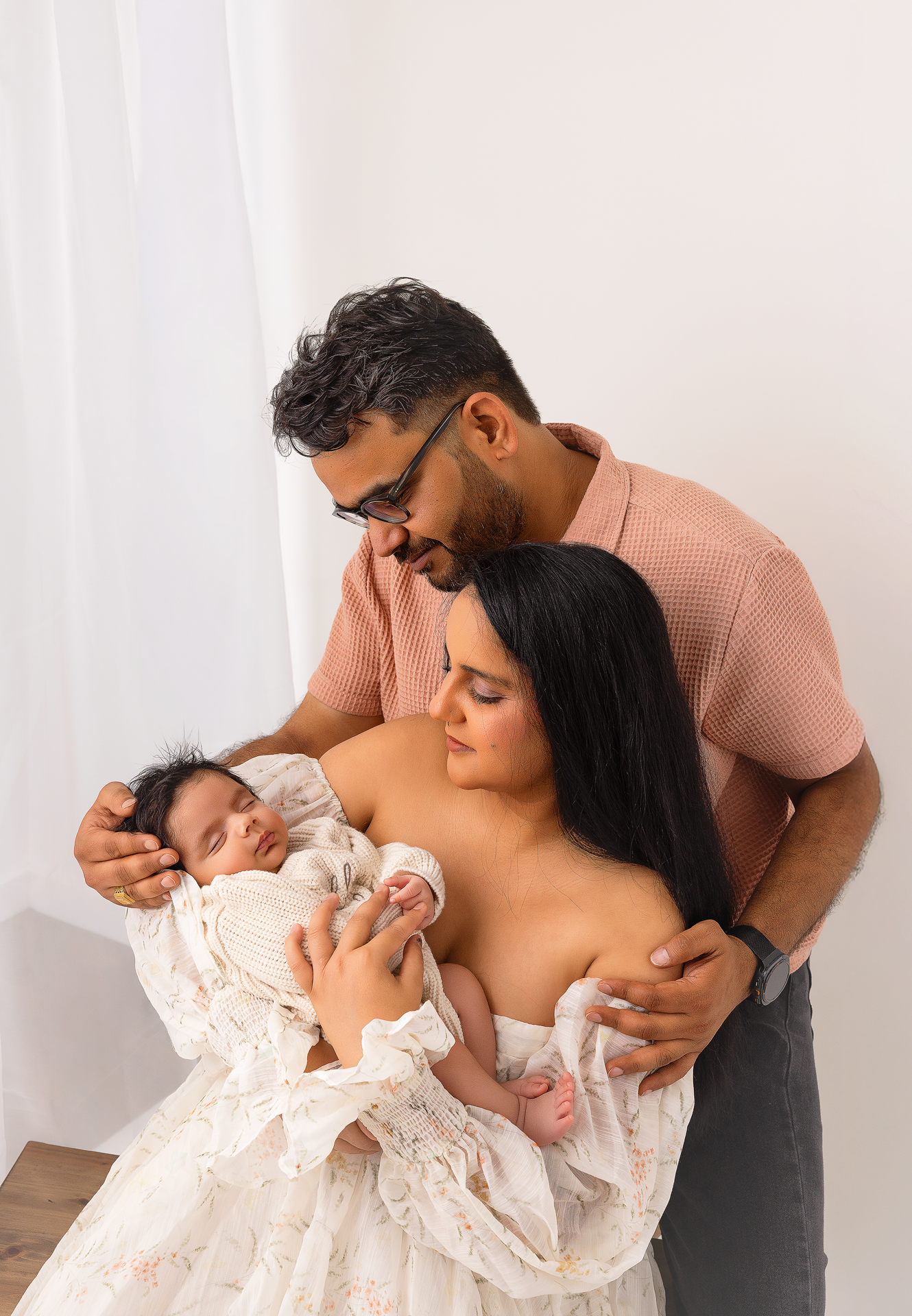 A tender family moment captured in a series of intimate black and white photographs against a light background.