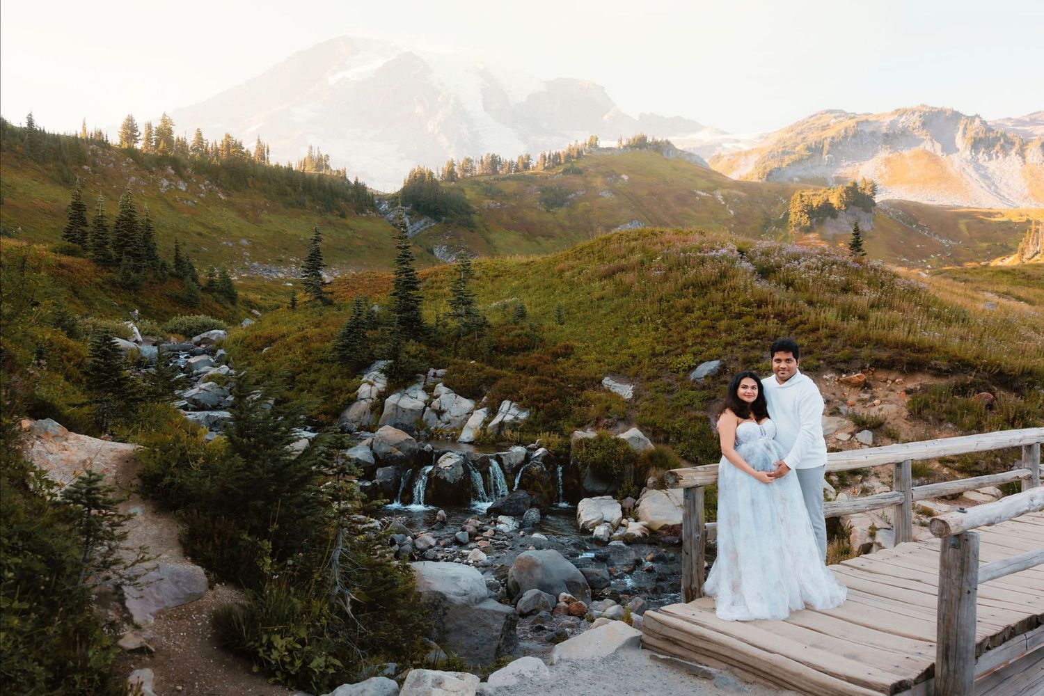Scenic mountain wedding ceremony setup with wooden chairs and floral arrangements at sunset in an alpine setting.