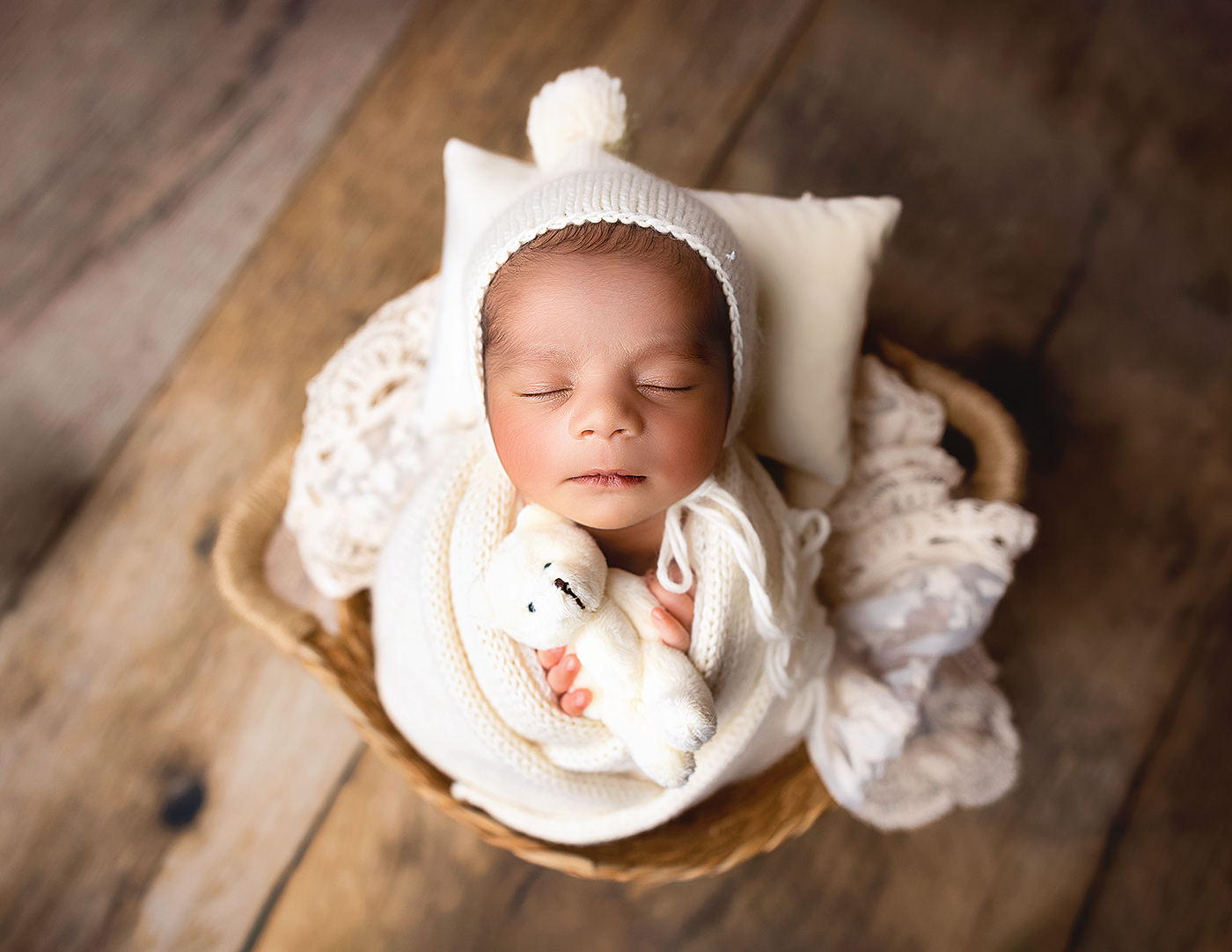 Peaceful newborn baby sleeping in cozy white blankets during a newborn photography session in Bothell