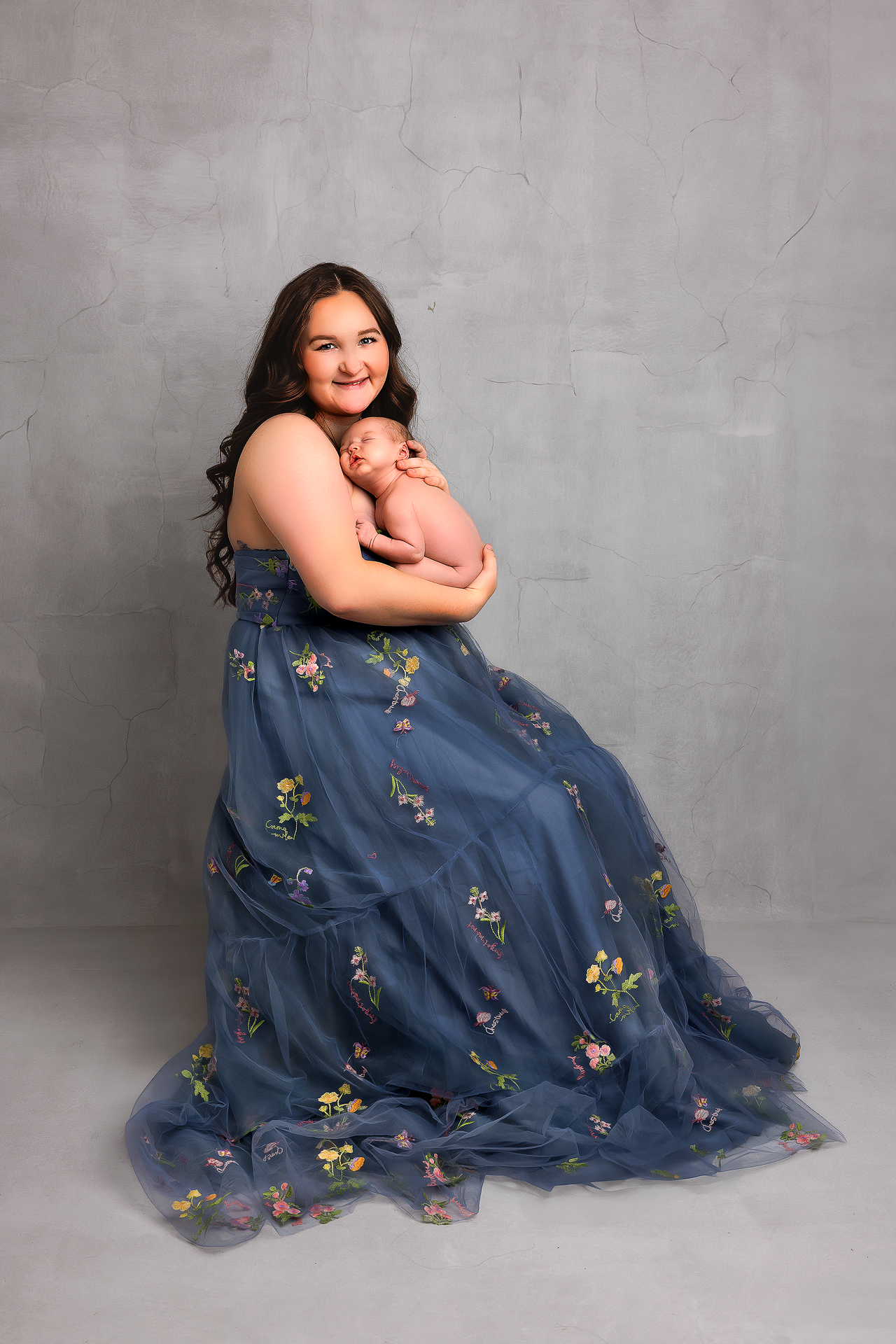 A series of studio portraits showing a person in a flowing blue floral dress against a gray backdrop.