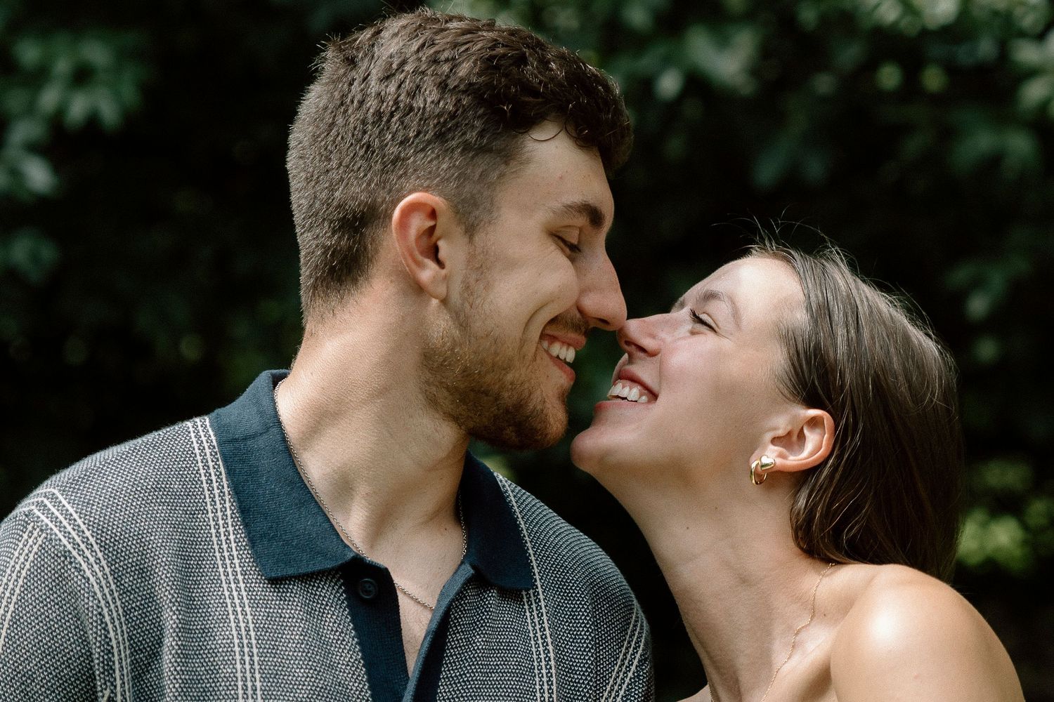 Romantic outdoor photo series of couple laughing and embracing in natural light.