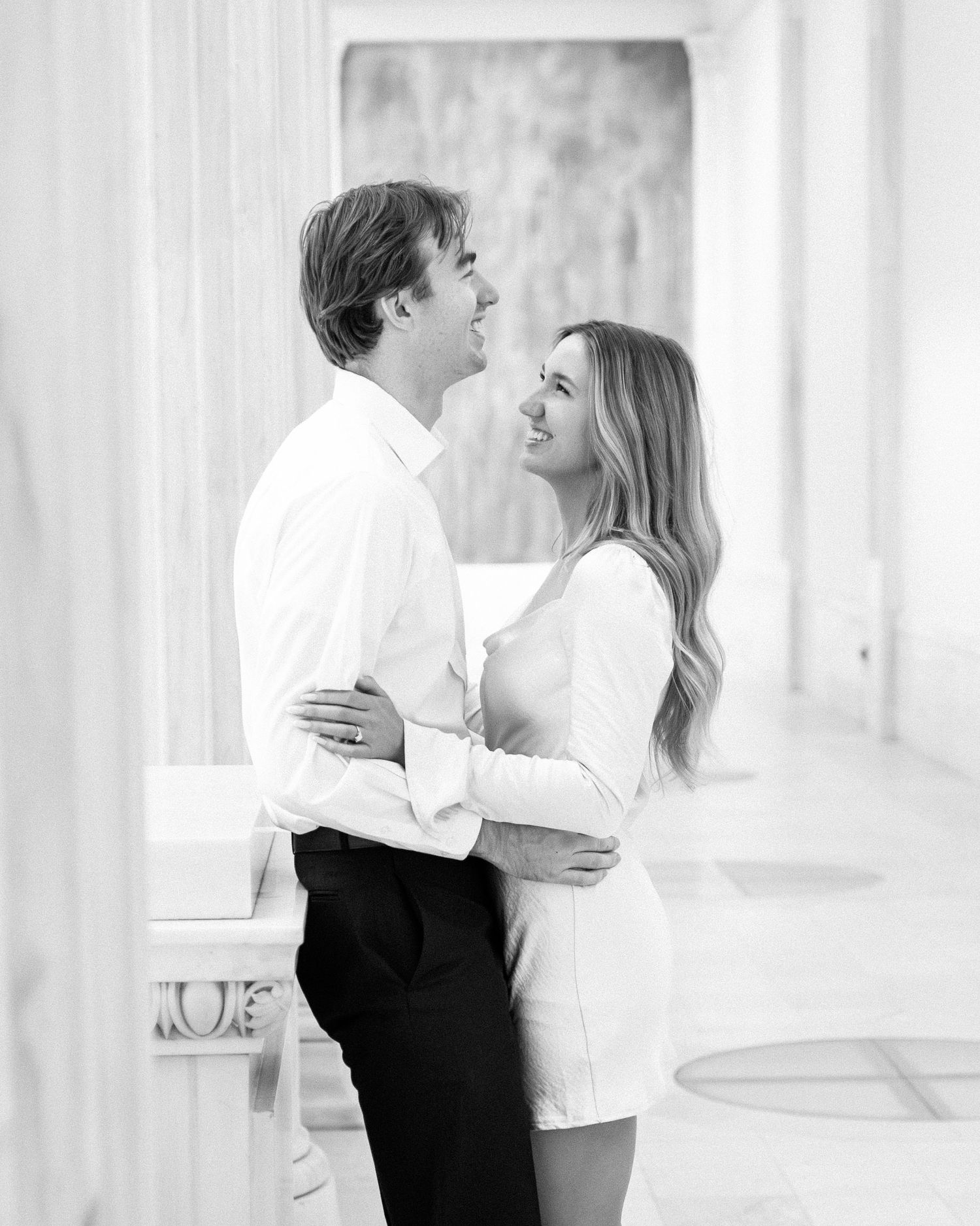 Romantic black and white engagement photo sequence in a bright studio setting.