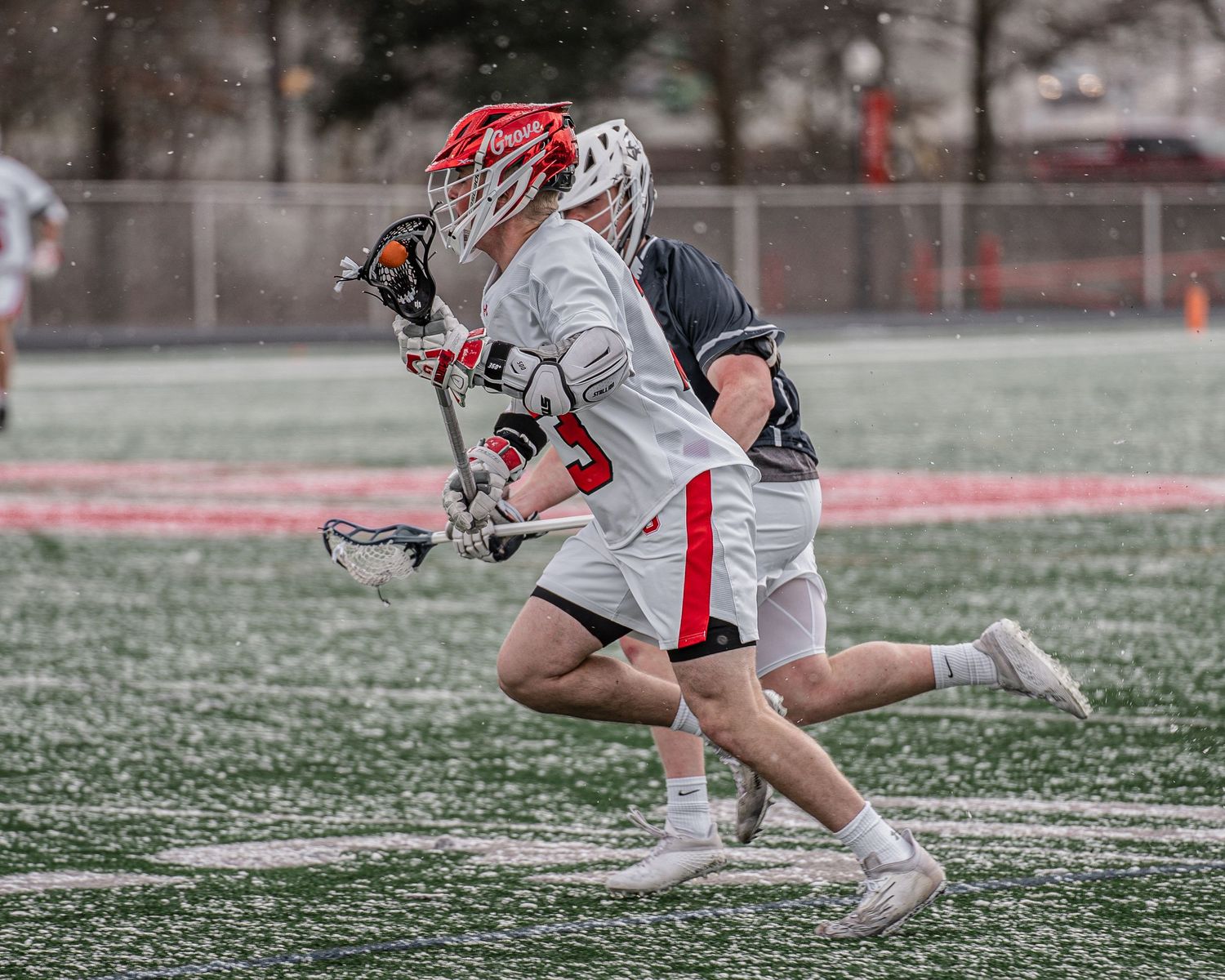 A sequence of images showing a crosse head in motion during lacrosse play on an artificial turf field.