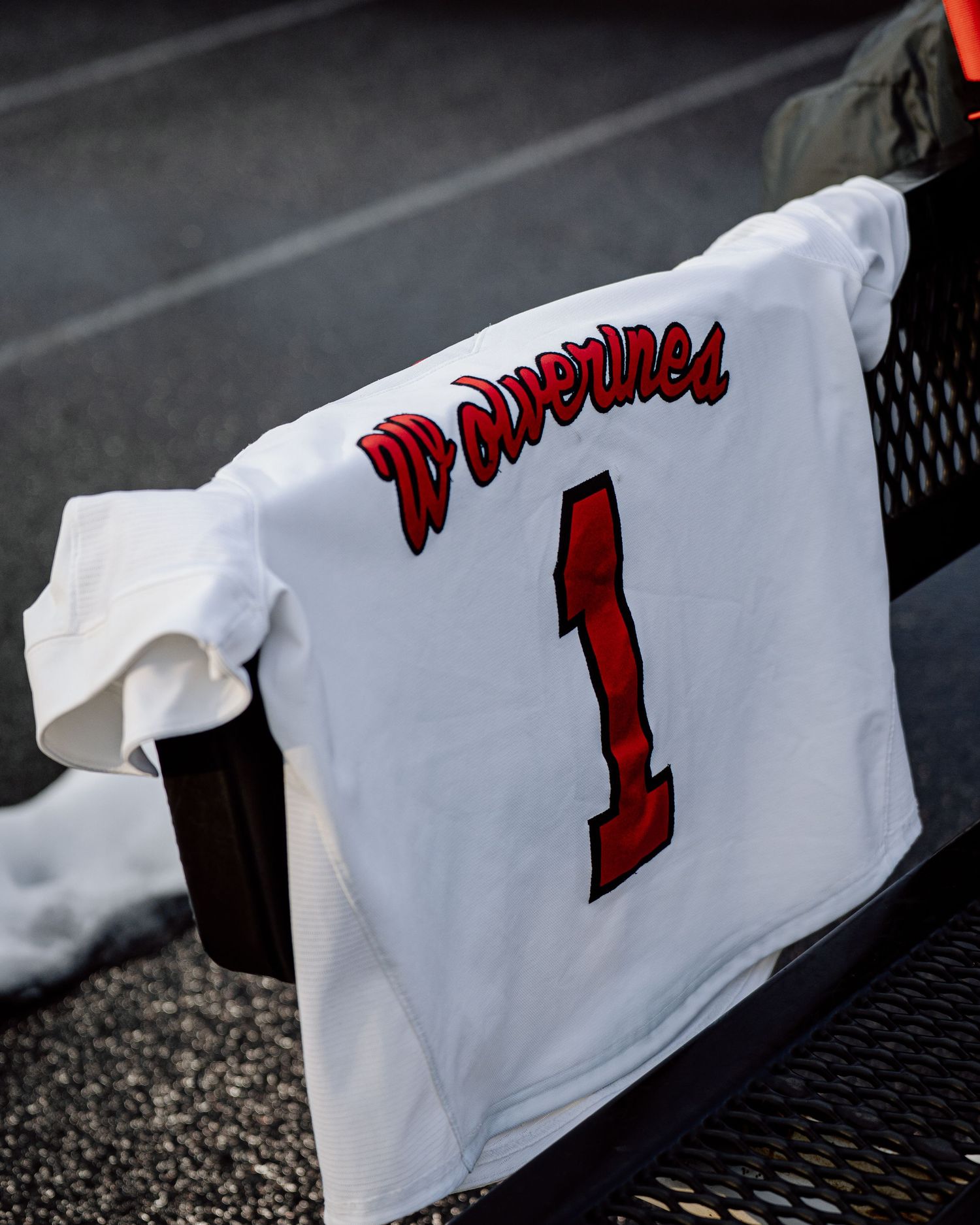A sequence of white t-shirts with red text displayed on a dark surface showing progressive text reveal.