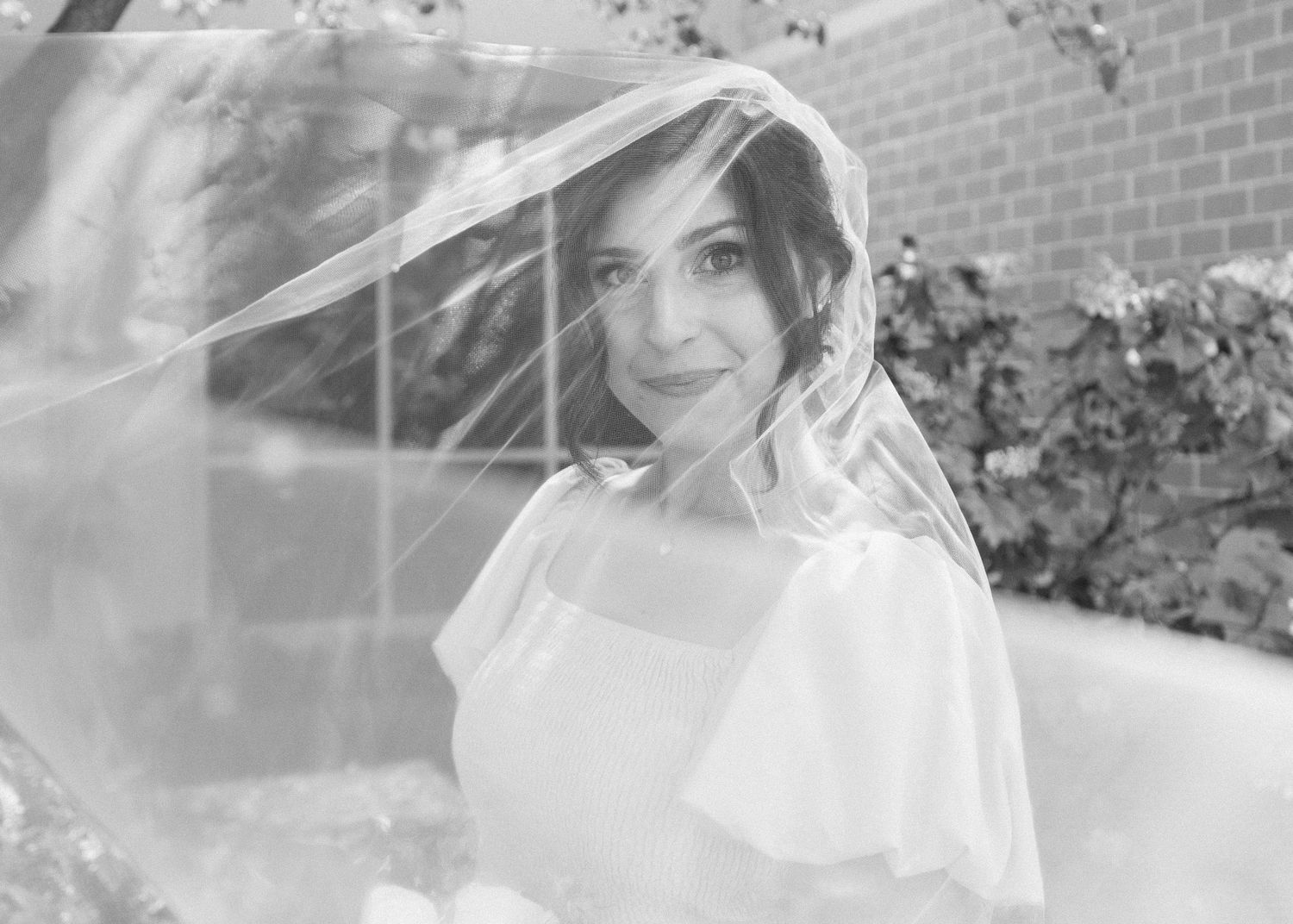 A black and white photo series shows a person in a wedding dress posing in various romantic outdoor settings.