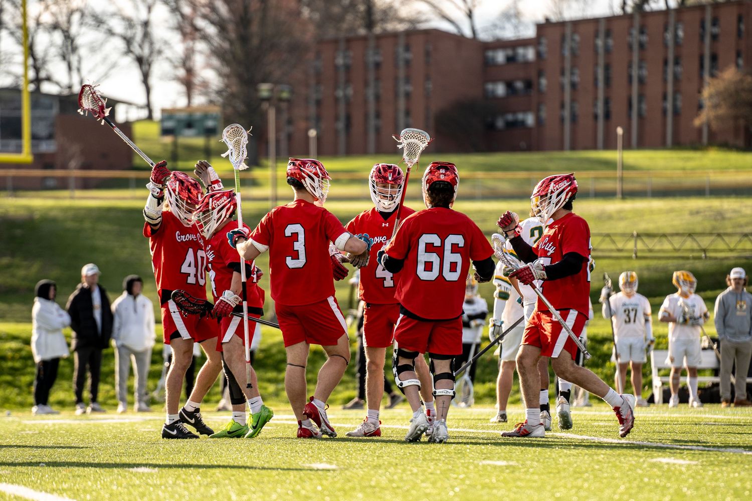 Sports team sitting together on grass field during practice session.