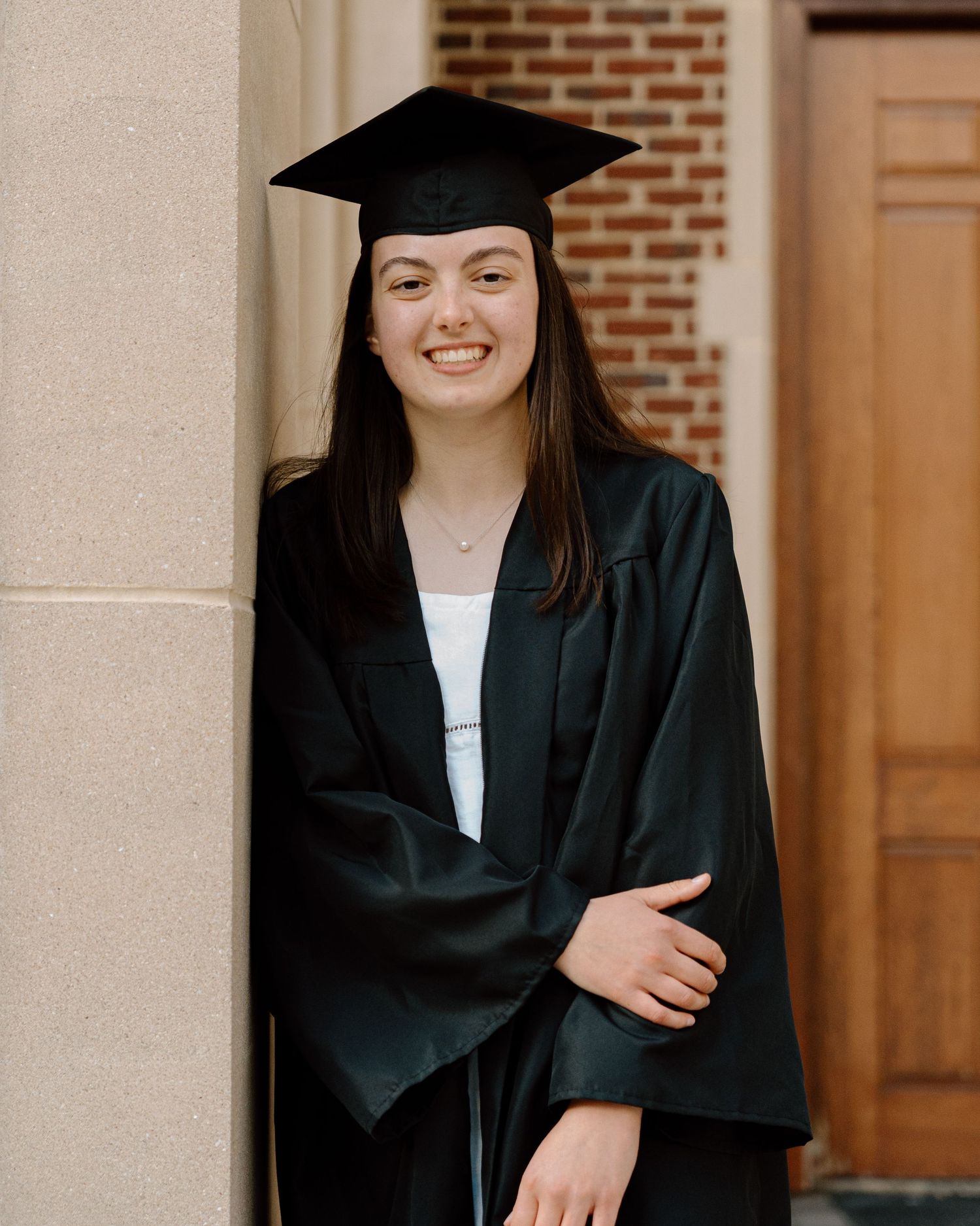 Graduate portrait sequence showing cap and gown against brick wall background.