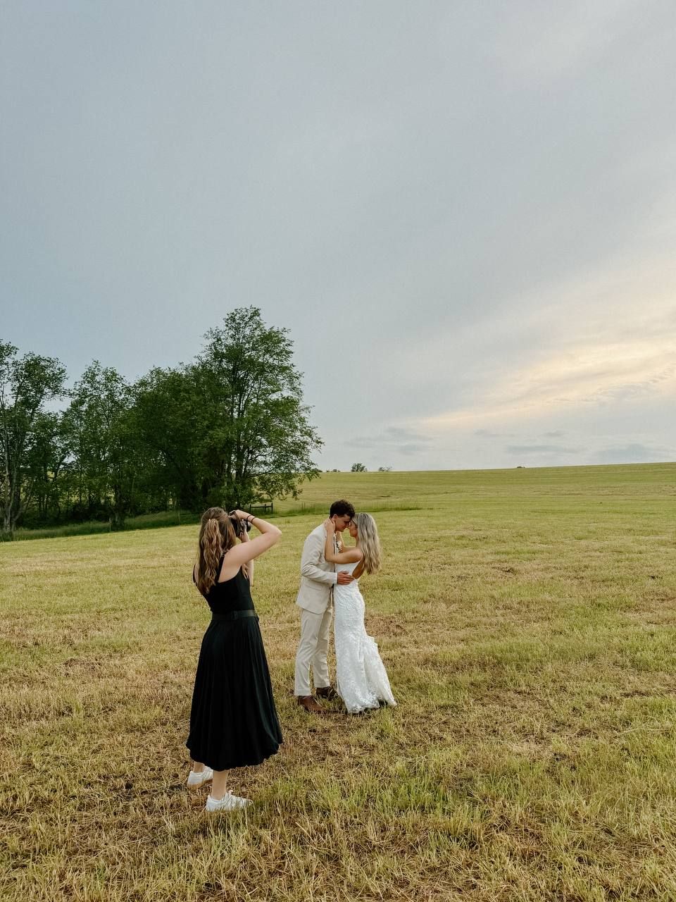 Friends dancing and twirling in a sunlit grassy field.