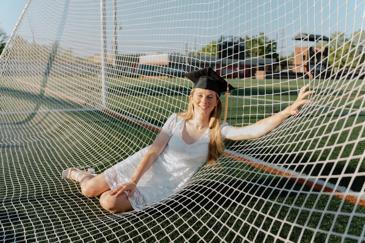 Students relaxing in a hammock net on a sunny day outside on campus.