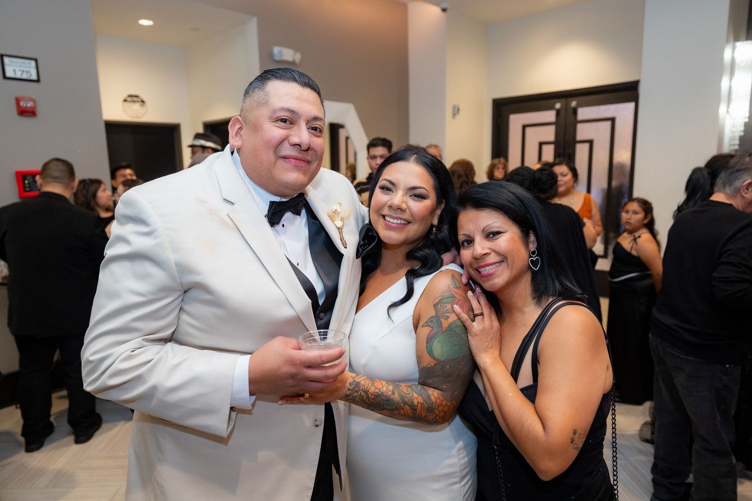 Wedding guests enjoying themselves at an indoor reception venue with modern decor.