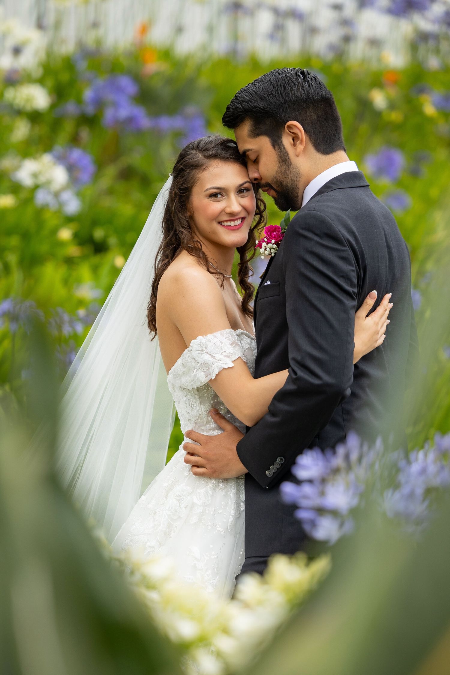 A romantic wedding moment captured among colorful wildflowers in a garden setting.