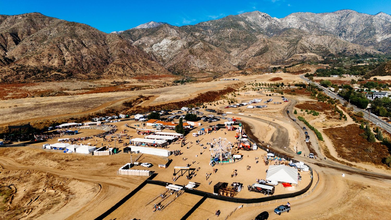 Drone shot of a desert RV campsite with mountains in the background.