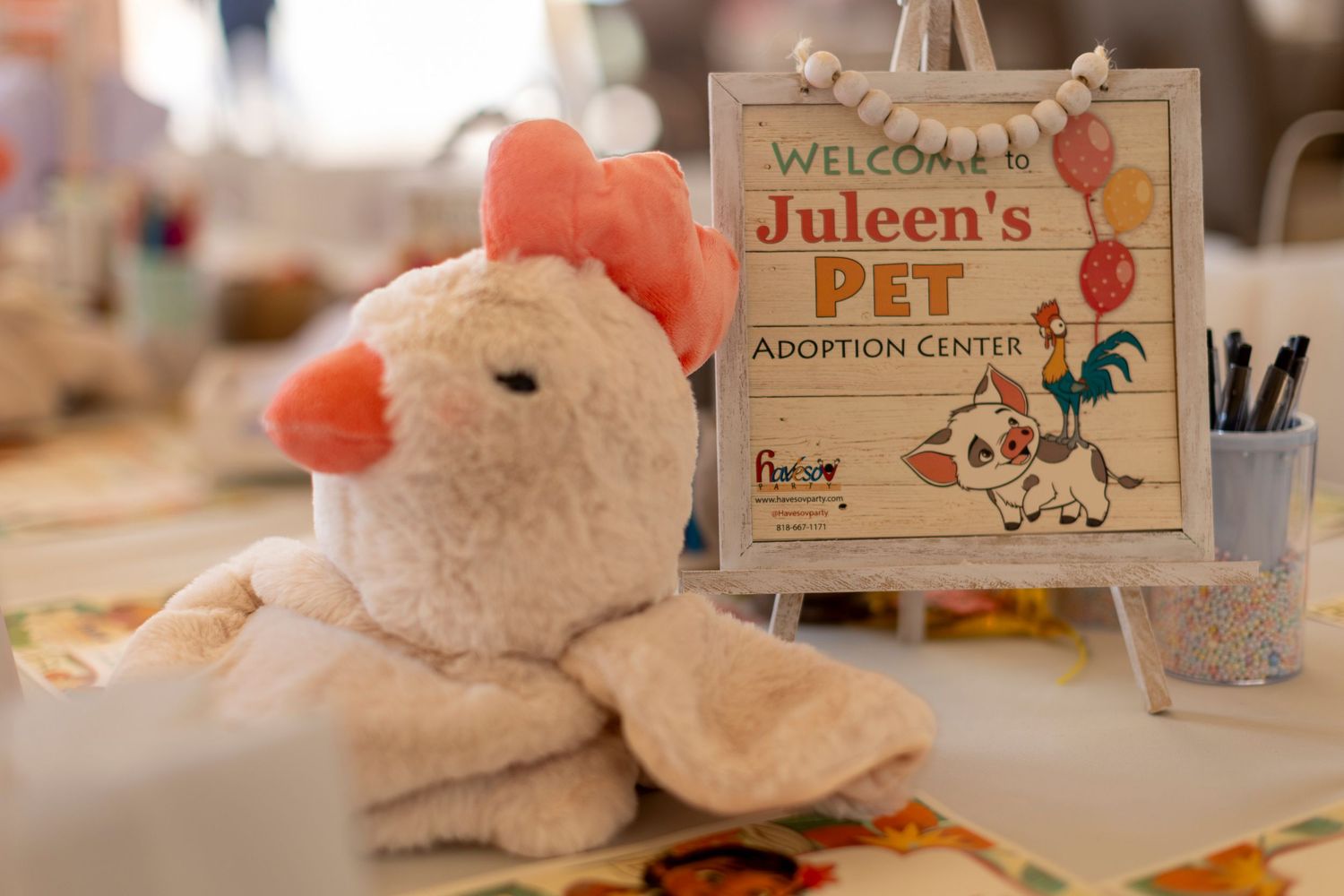 Pet adoption center themed party decor with plush animals and welcome signs in Huntington Beach.