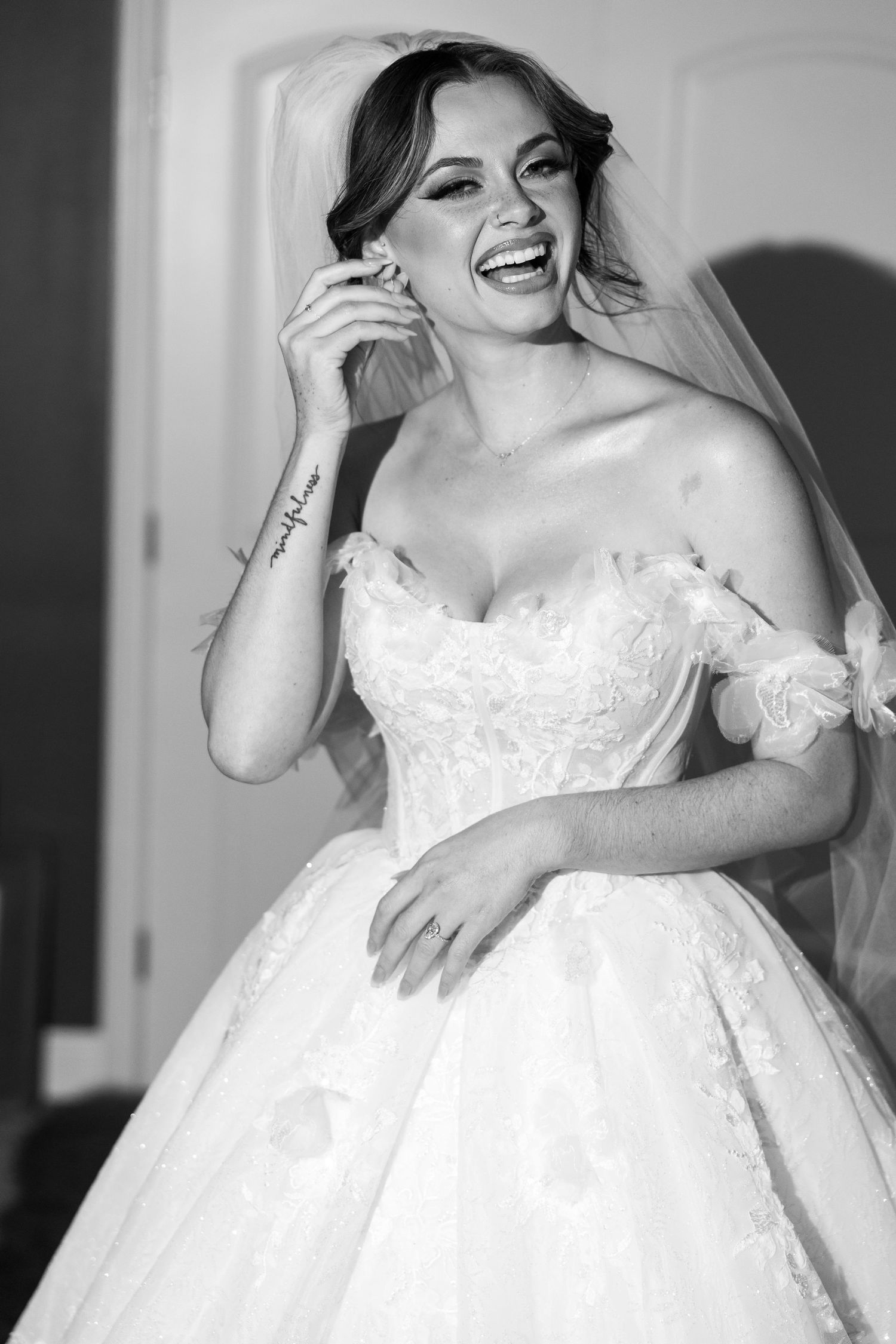 A joyful moment captured in black and white showing a bride in a classic ballgown wedding dress.