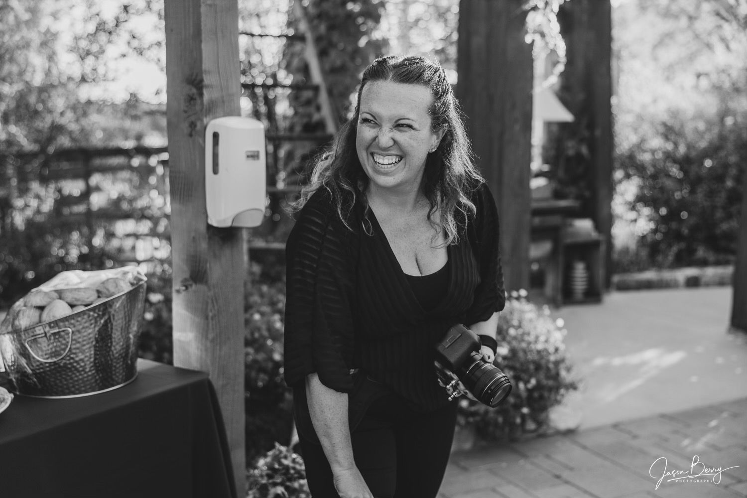 Black and white candid photo of photographer at outdoor event.
