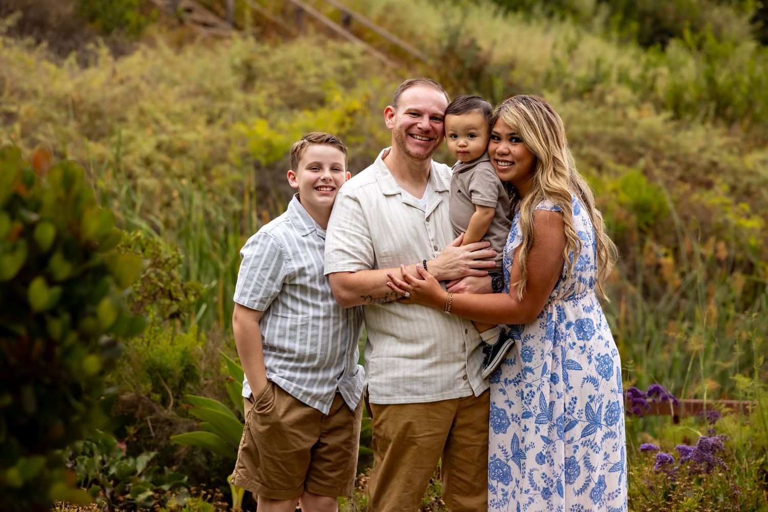 Family portrait session in golden afternoon light among wildflowers.