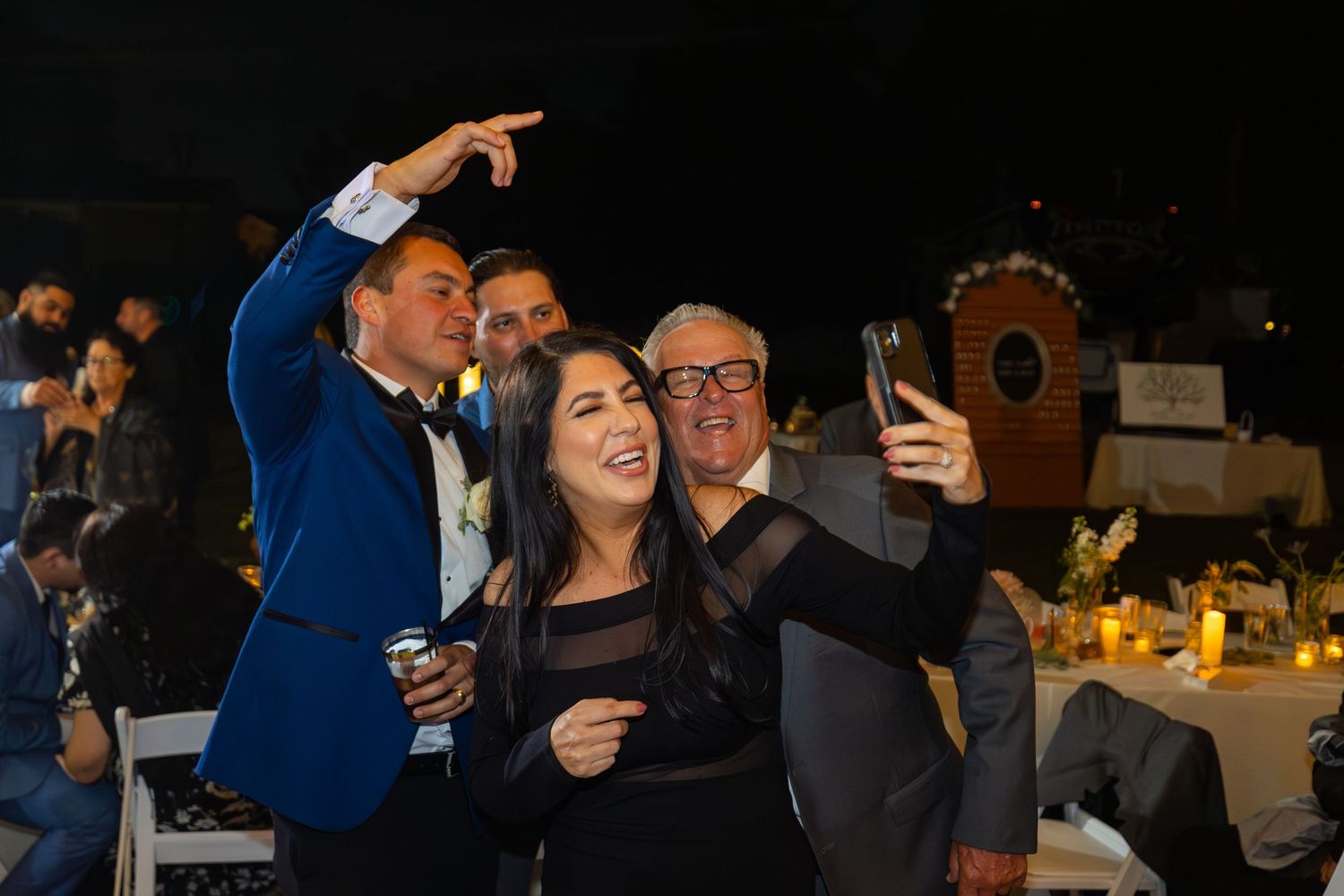 Wedding guests dancing and celebrating at an evening reception.