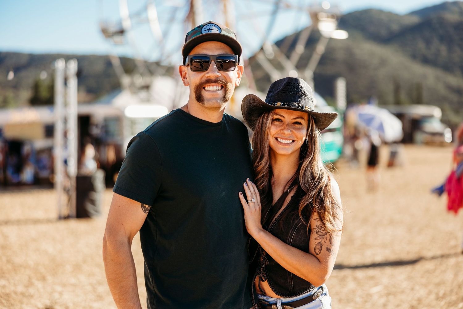Sunny outdoor portrait at a desert festival with mountains in background.