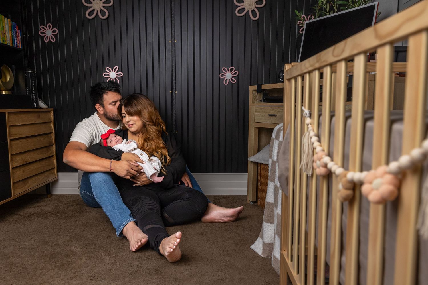 Mom and dad holding newborn baby in their LA home