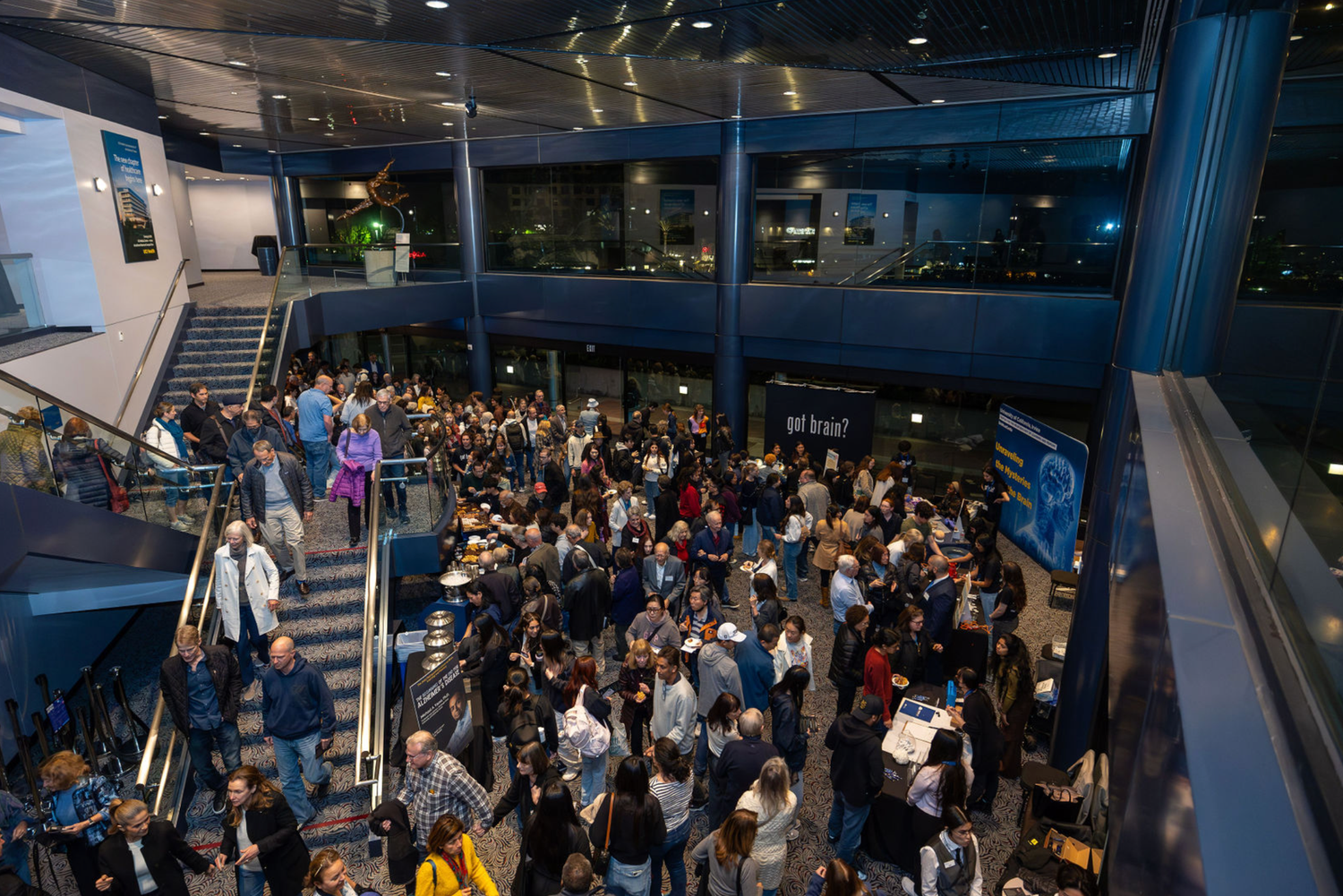 A large crowd of people gathered at night in what appears to be an airport terminal or transportation hub.