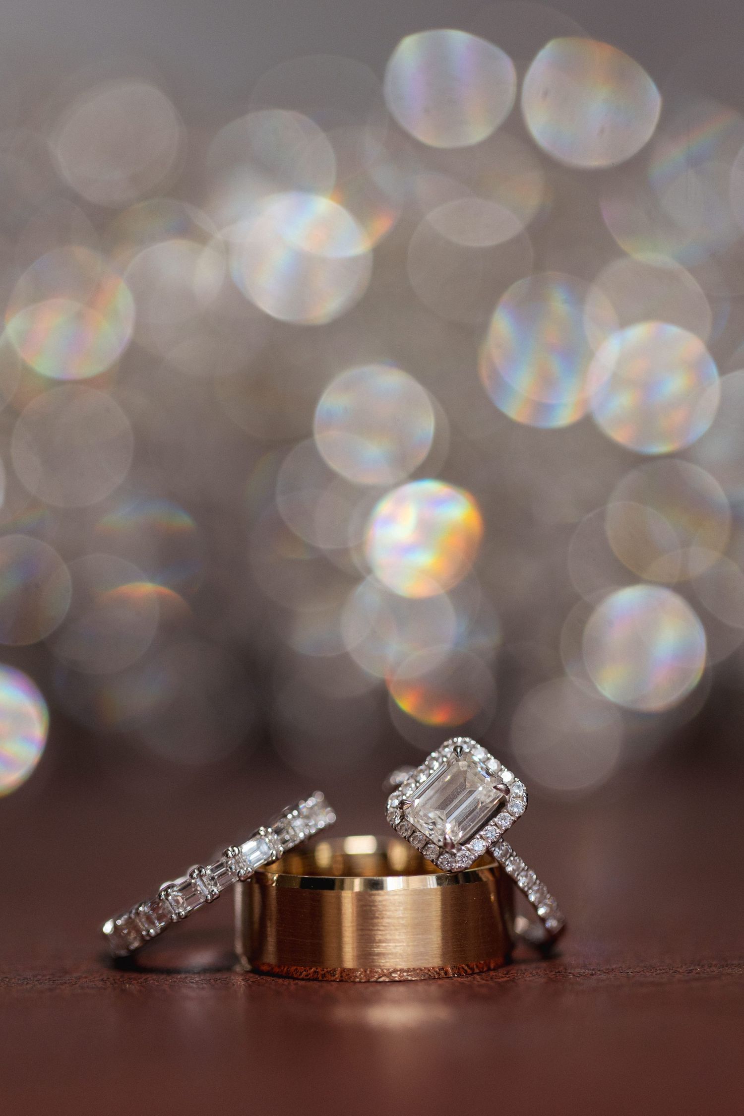 Wedding rings photographed with sparkling bokeh background effects.
