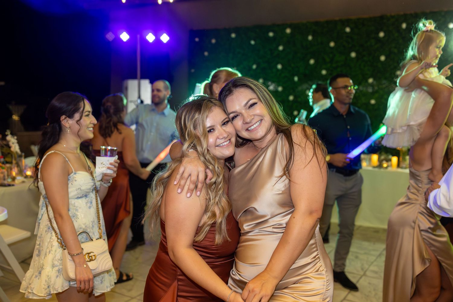 Wedding reception dance party with colorful lighting and festive atmosphere.
