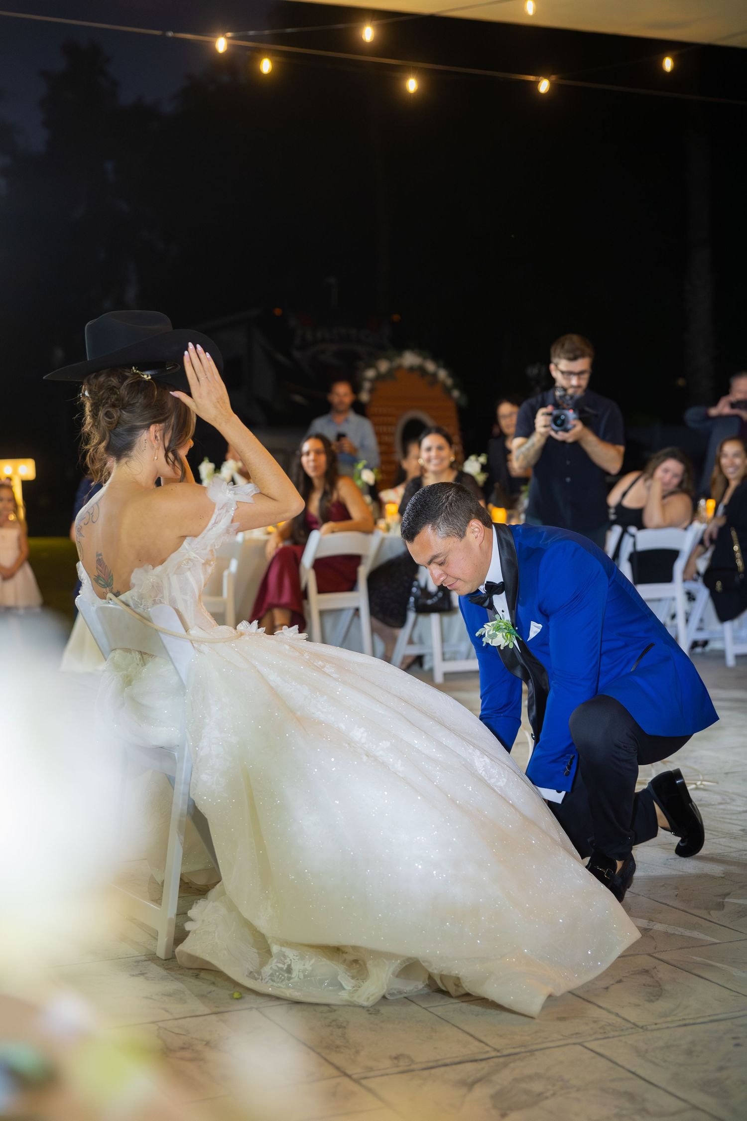 Wedding couple performing a dramatic dip dance move on an outdoor dance floor.