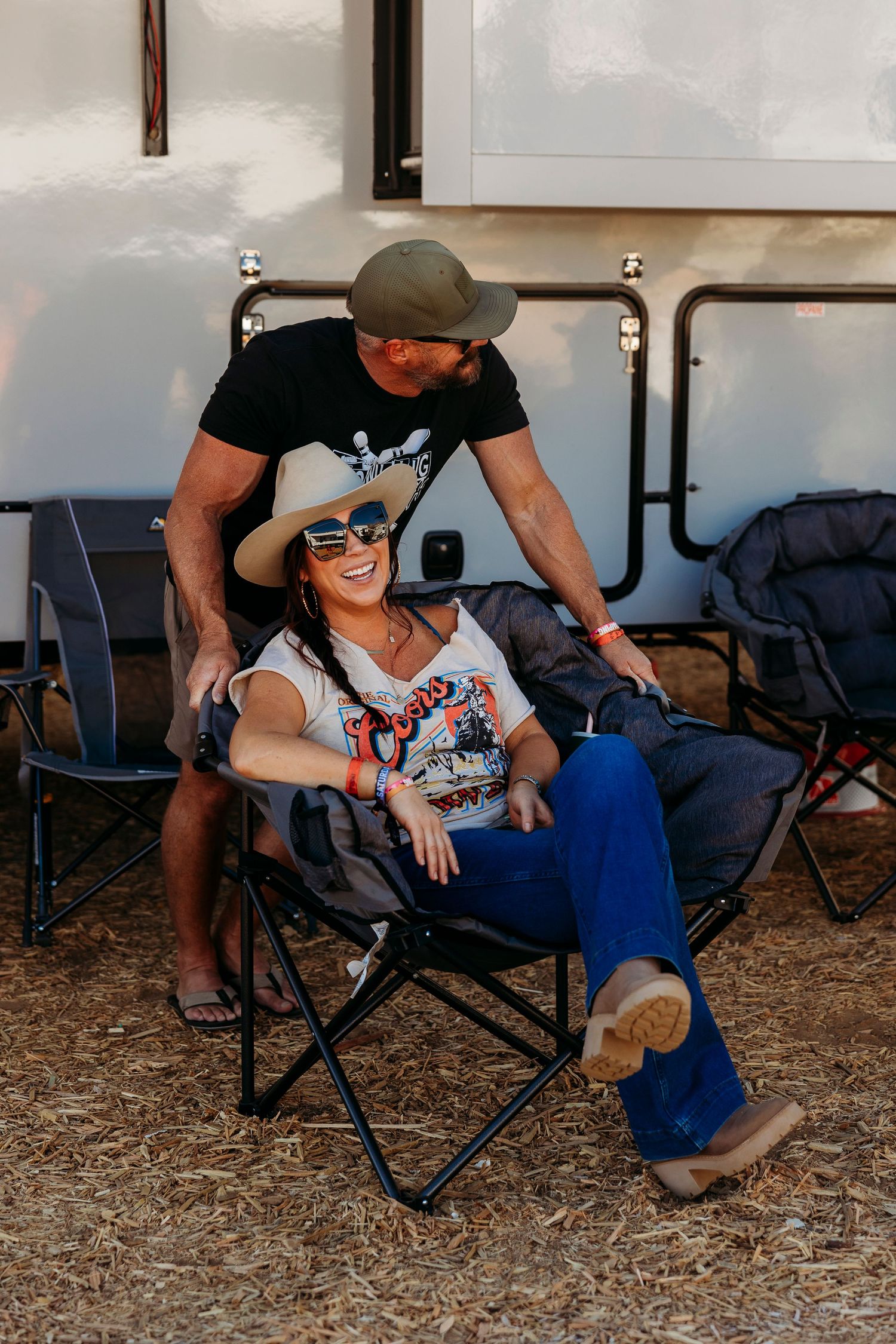 Casual outdoor seating arrangement beside an RV at a desert festival.