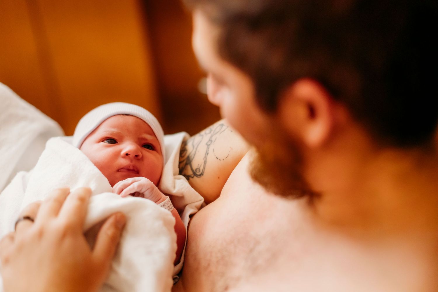 A peaceful moment between parent and baby with warm earthy tones glowing in the background light.