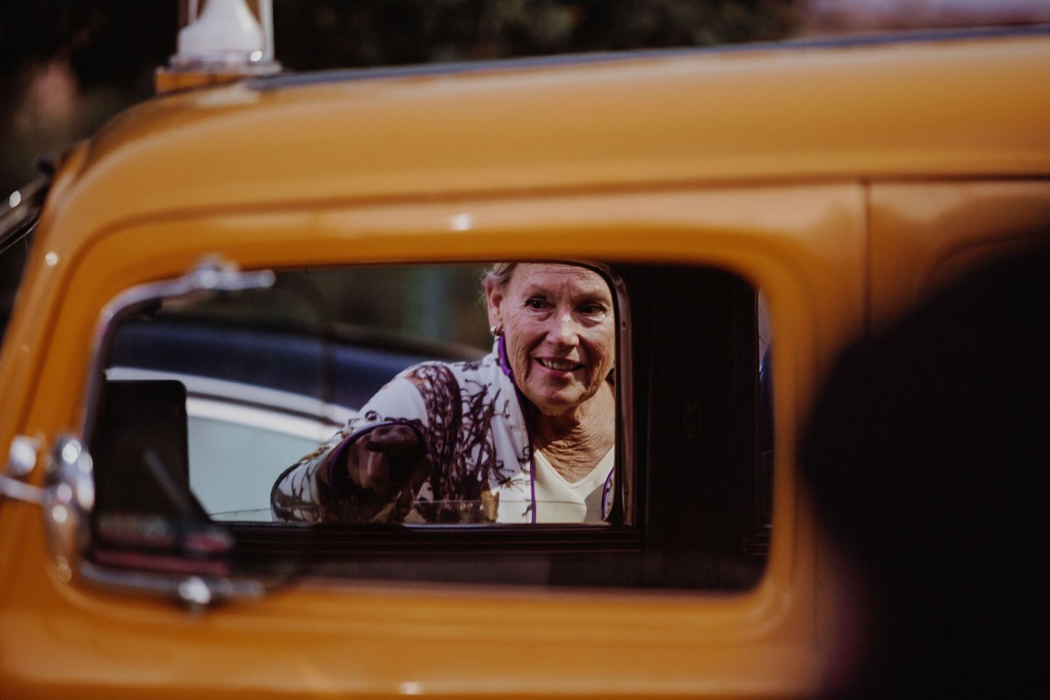 A collection of window reflections in yellow NYC taxi cabs shows passengers and street scenes.