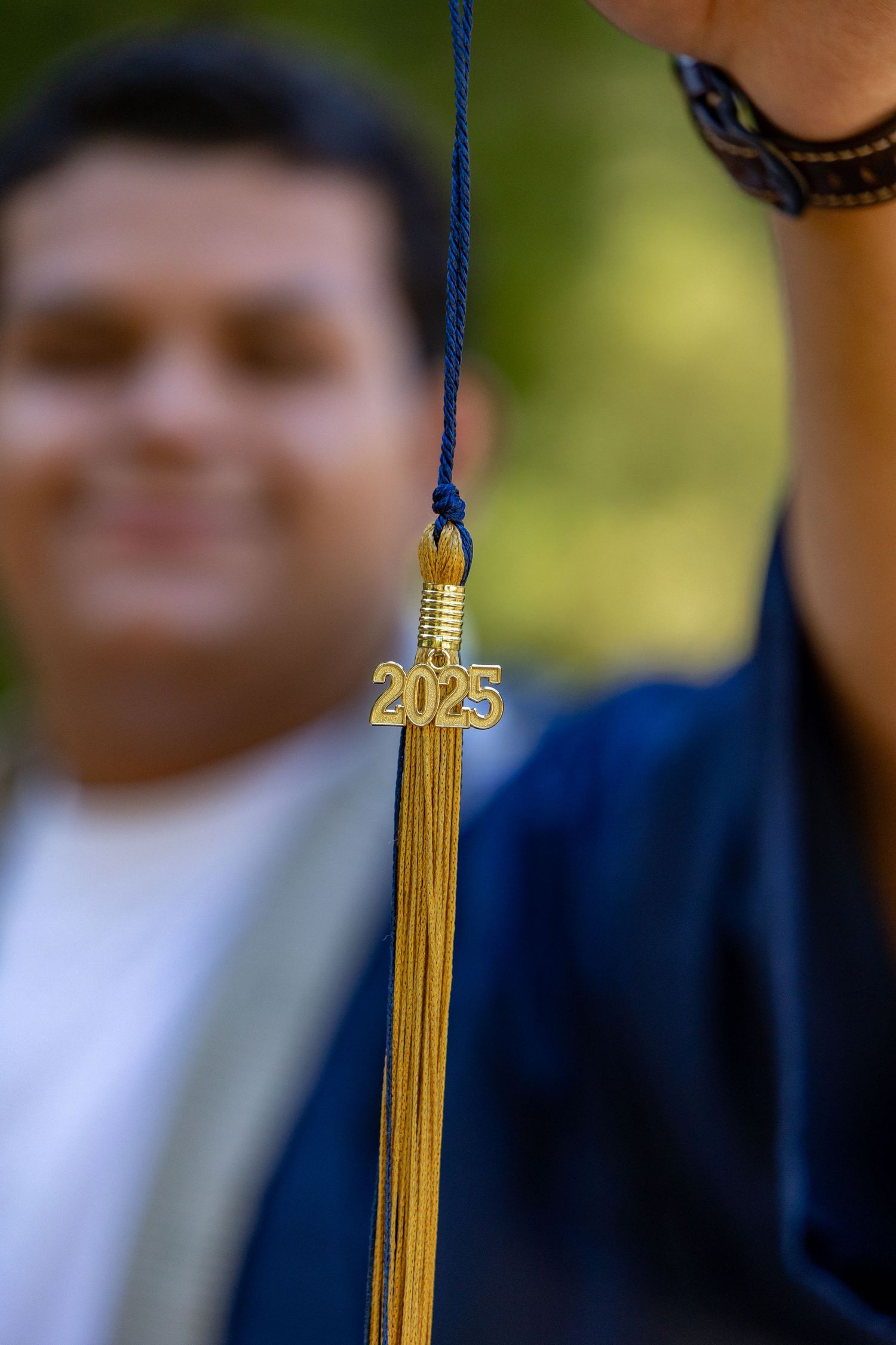 Close-up of a gold graduation tassel with 2025 charm hanging against a blurred background in Yucaipa.