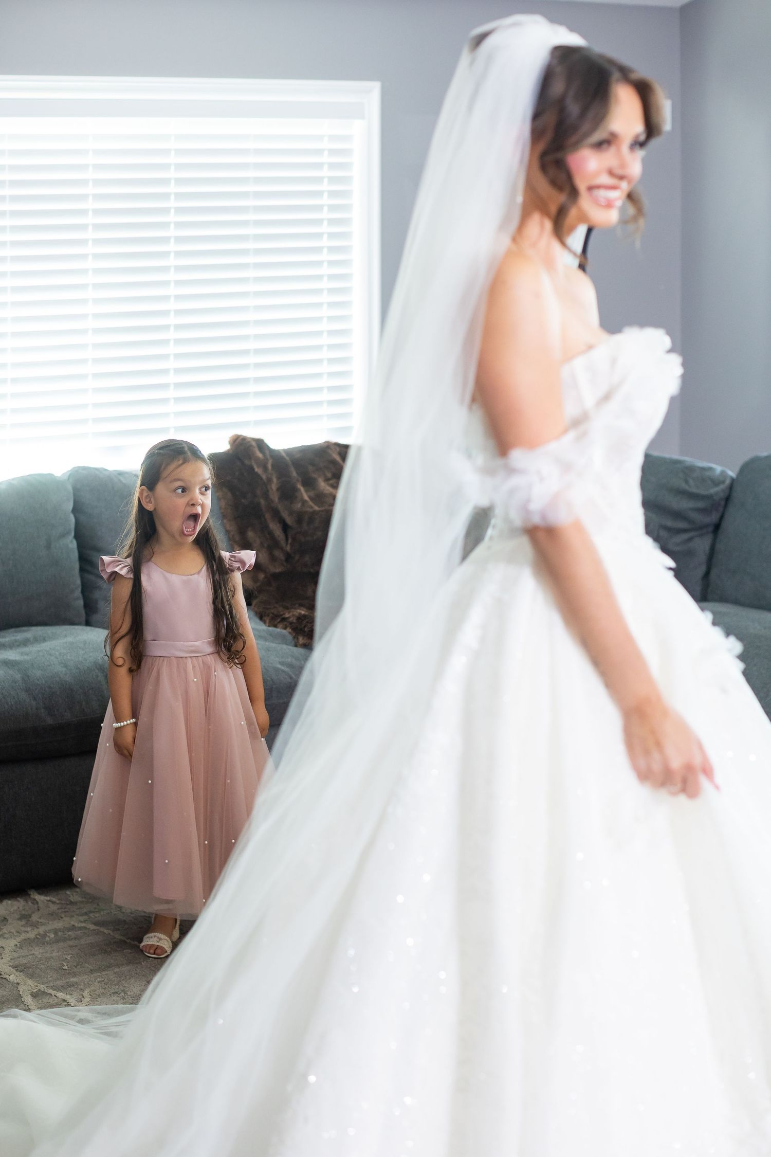 A candid reaction shot showing excitement during wedding preparations in a living room.