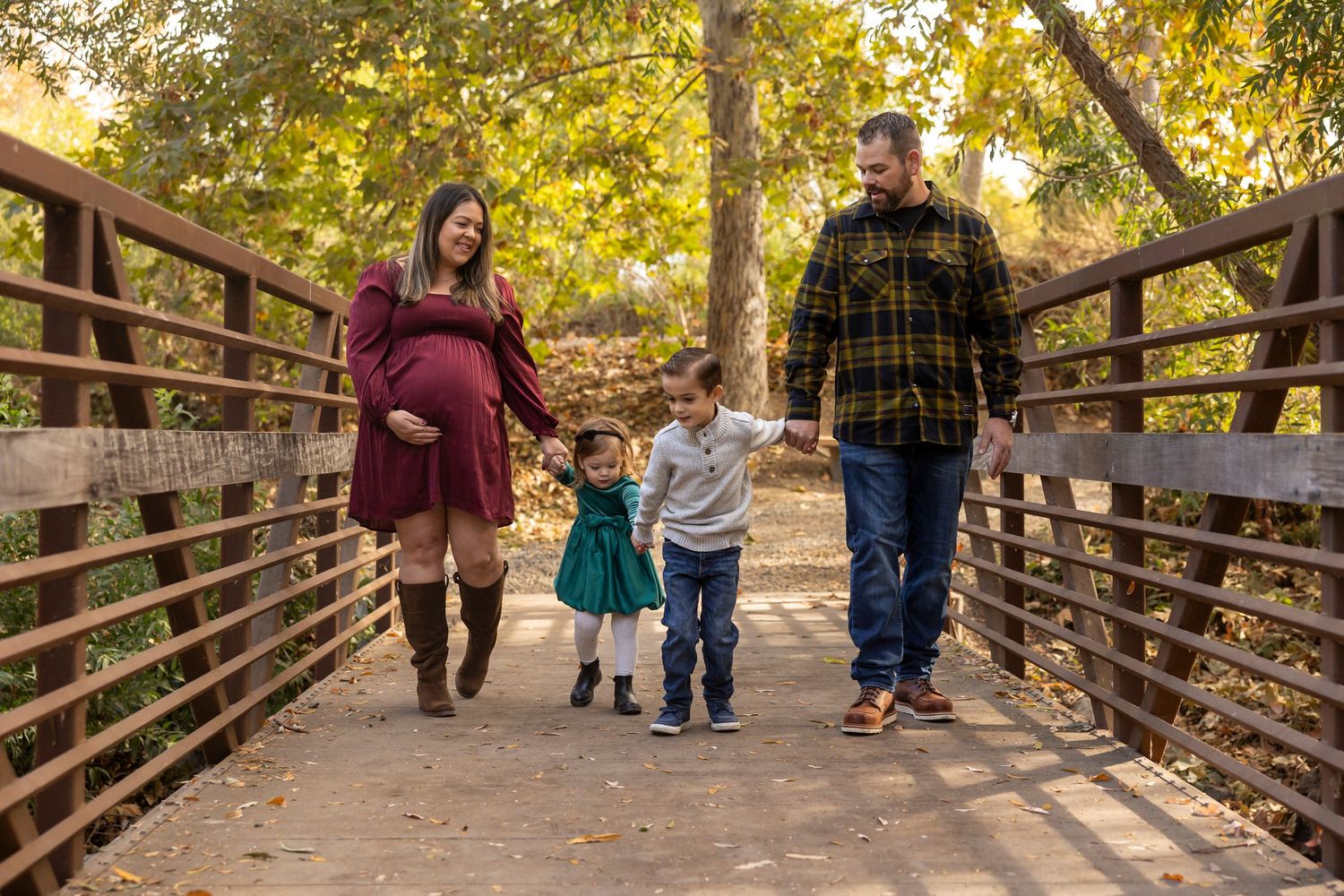 Autumn scene on wooden bridge walkway surrounded by golden-leaved trees.
