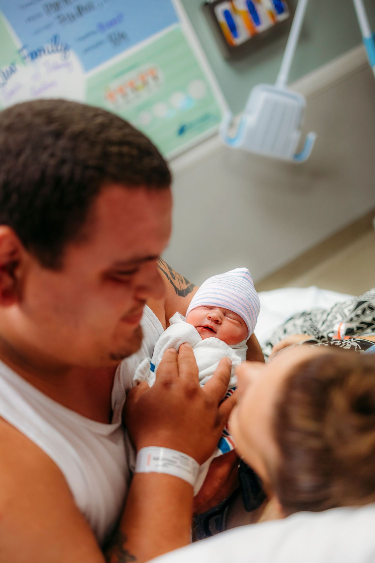 Emotional first moments between family and newborn in hospital room.