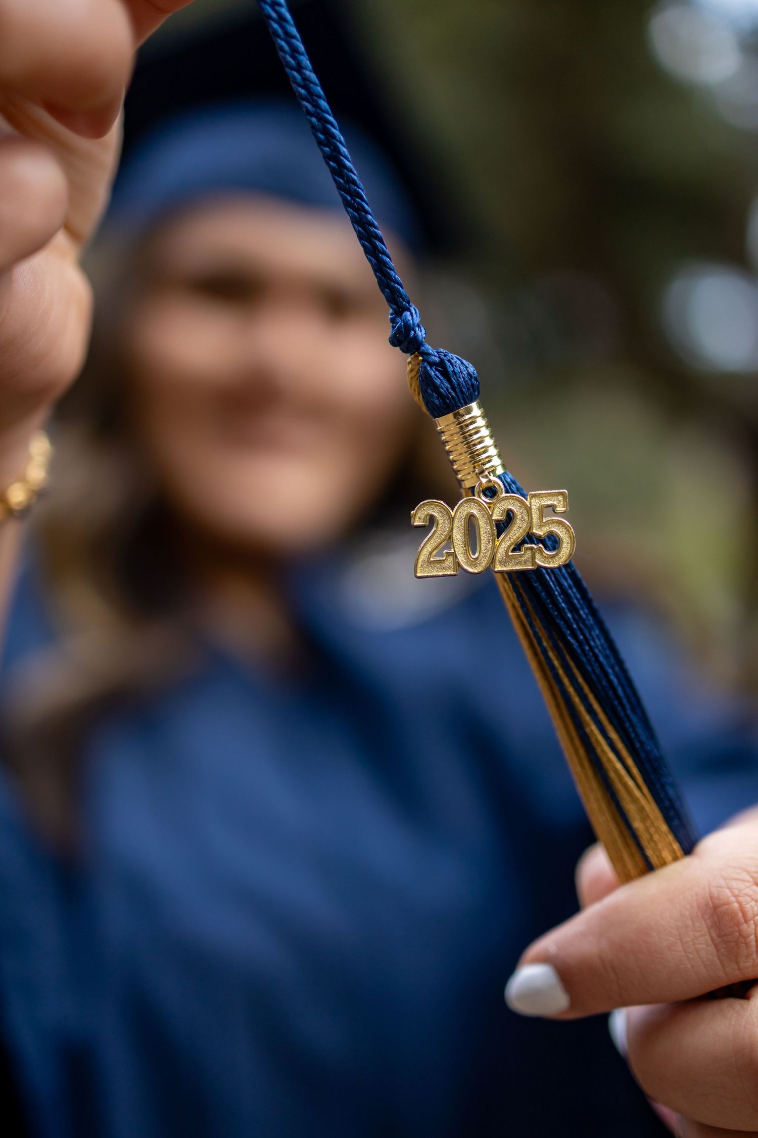 Close-up of a blue graduation tassel with gold 2025 charm against blurred background in Oak Glen.