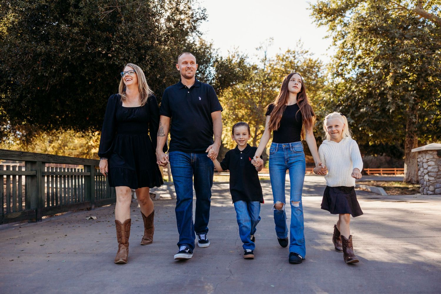 Family walking together on a paved path through a park on a sunny autumn day in Yucaipa.
