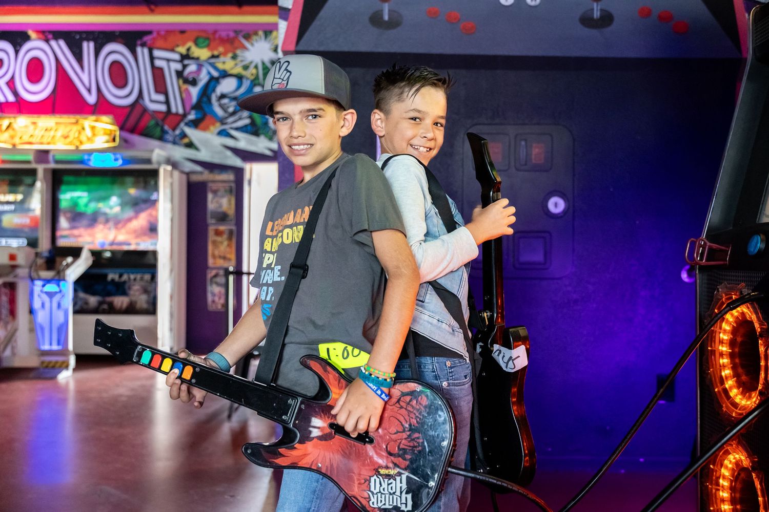 Friends enjoying arcade games with colorful neon lights in background in Calimesa.