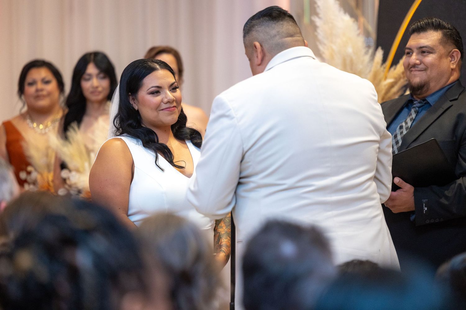 Guests celebrate during an elegant wedding reception with people dancing and socializing in formal attire.