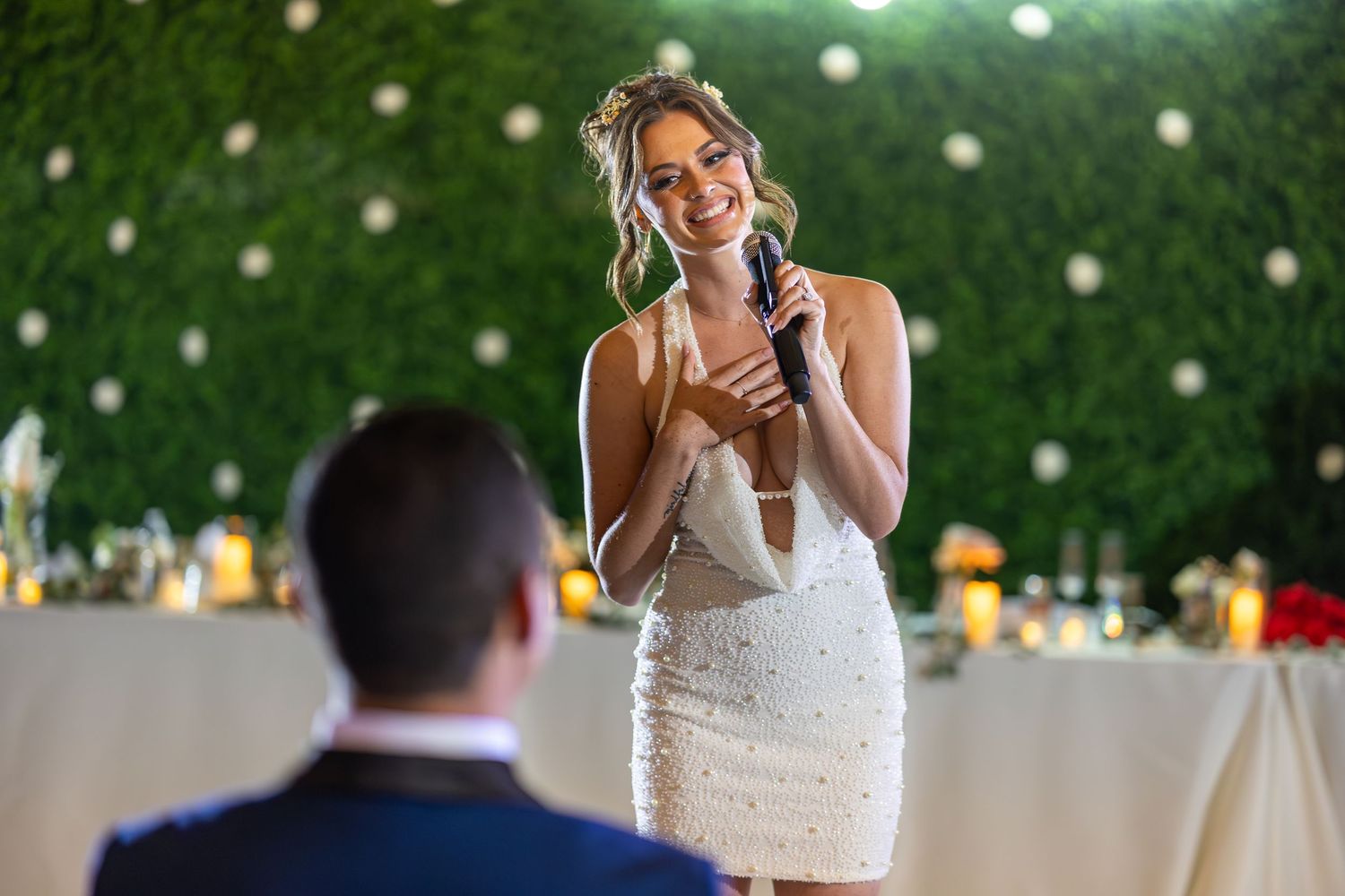 Wedding celebration with string lights and greenery backdrop creating a romantic atmosphere.