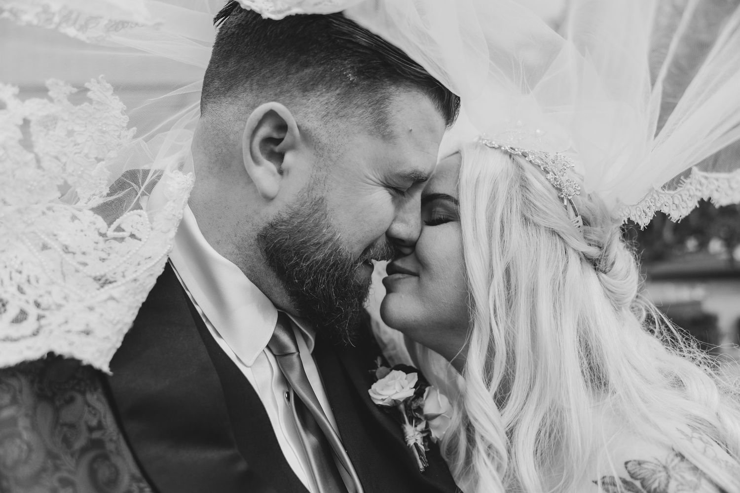 A romantic wedding moment captured in black and white with the couple sharing an intimate embrace.