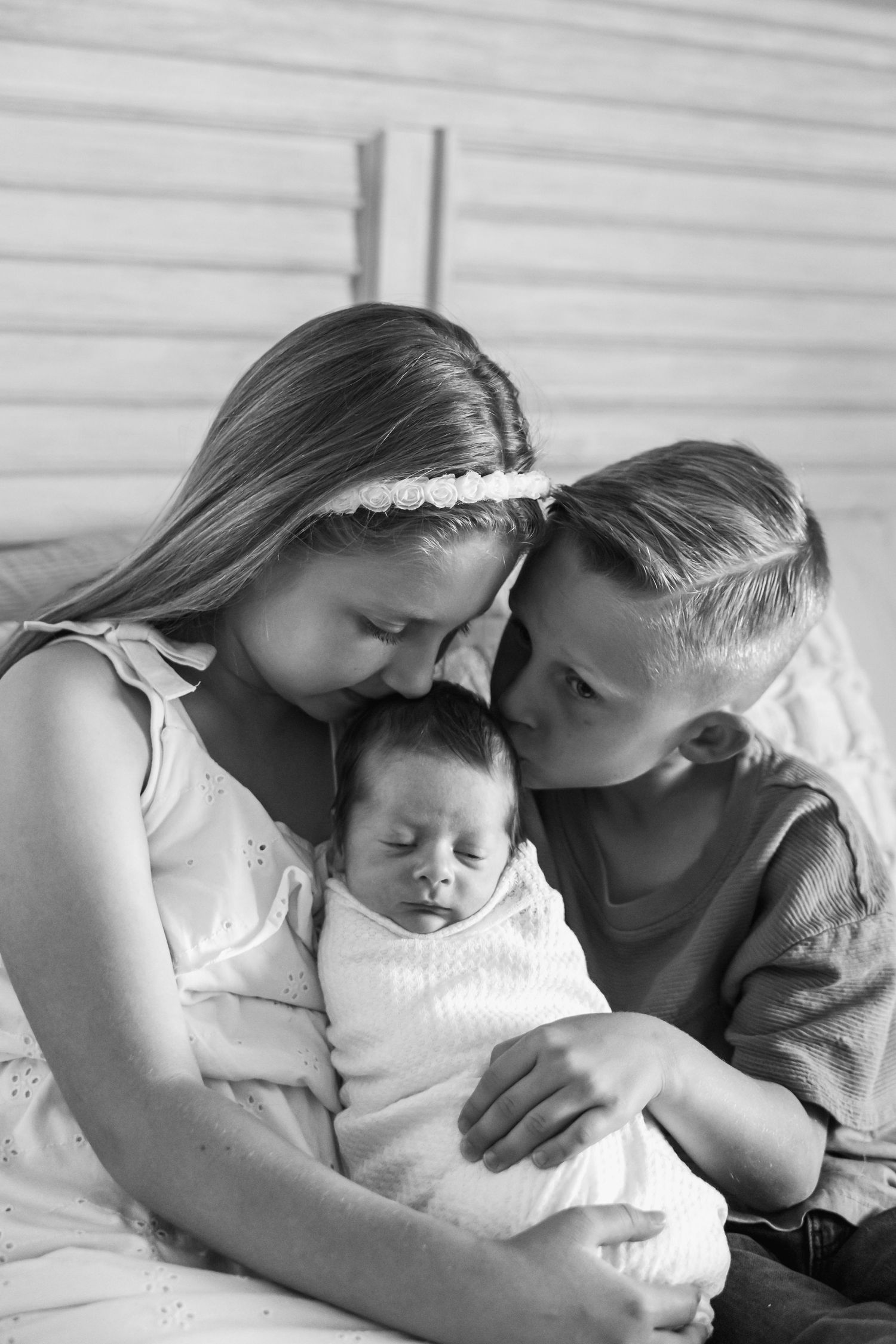 Siblings share tender moments together while resting on a couch in black and white sequence photos.