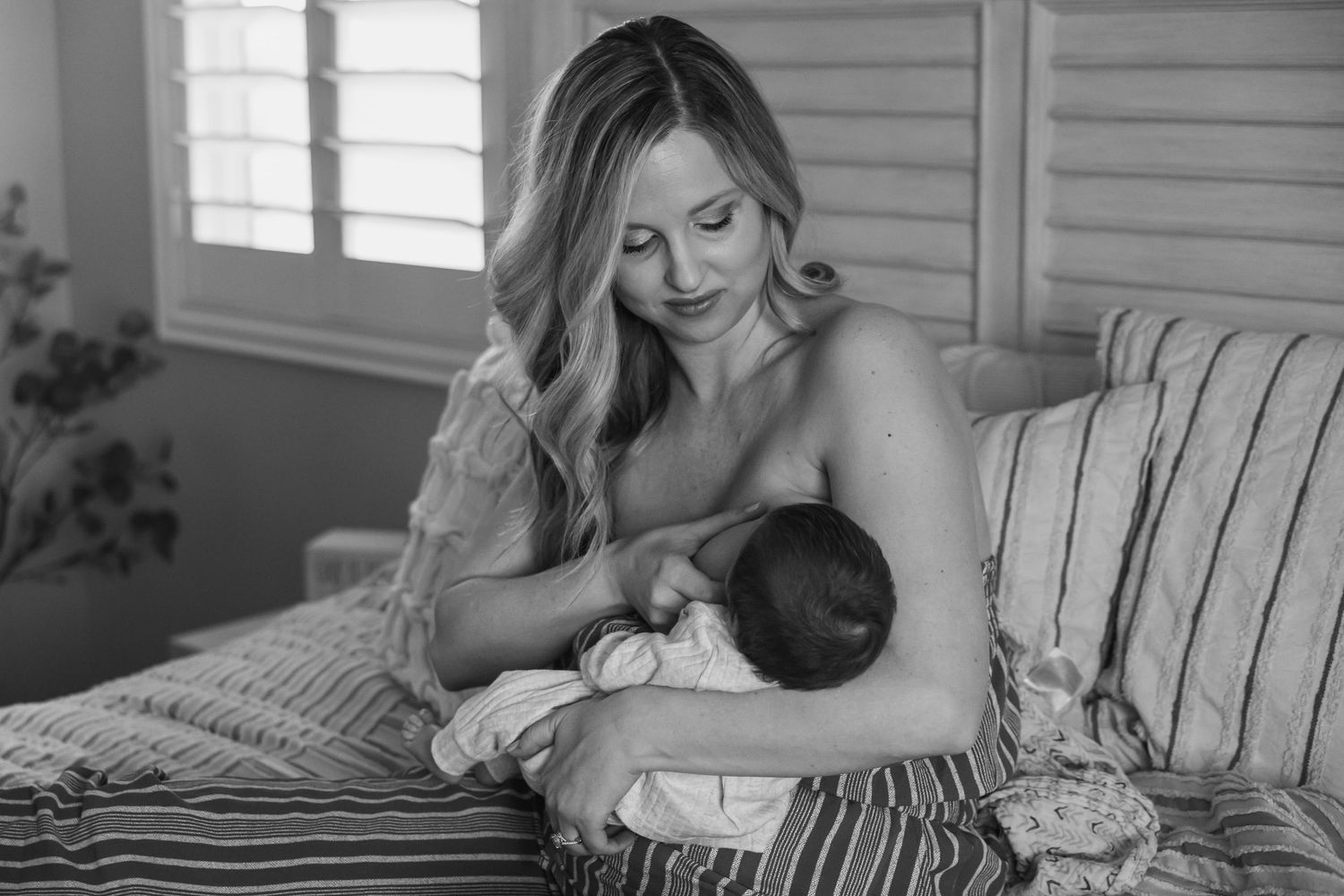 A black and white photo of mom breast feeding at home in Beaumont