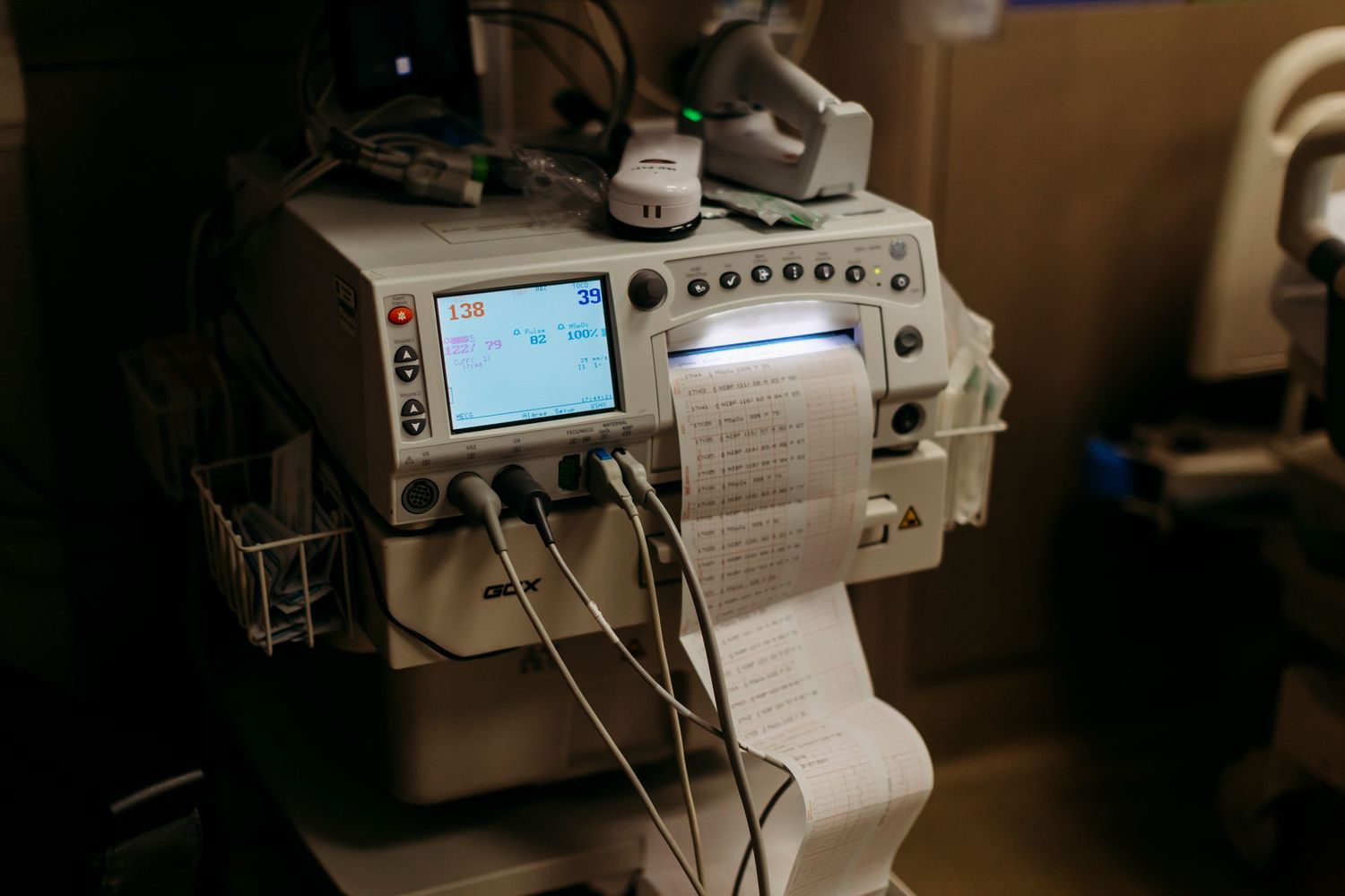 Medical monitoring equipment displays vital signs in a hospital room.