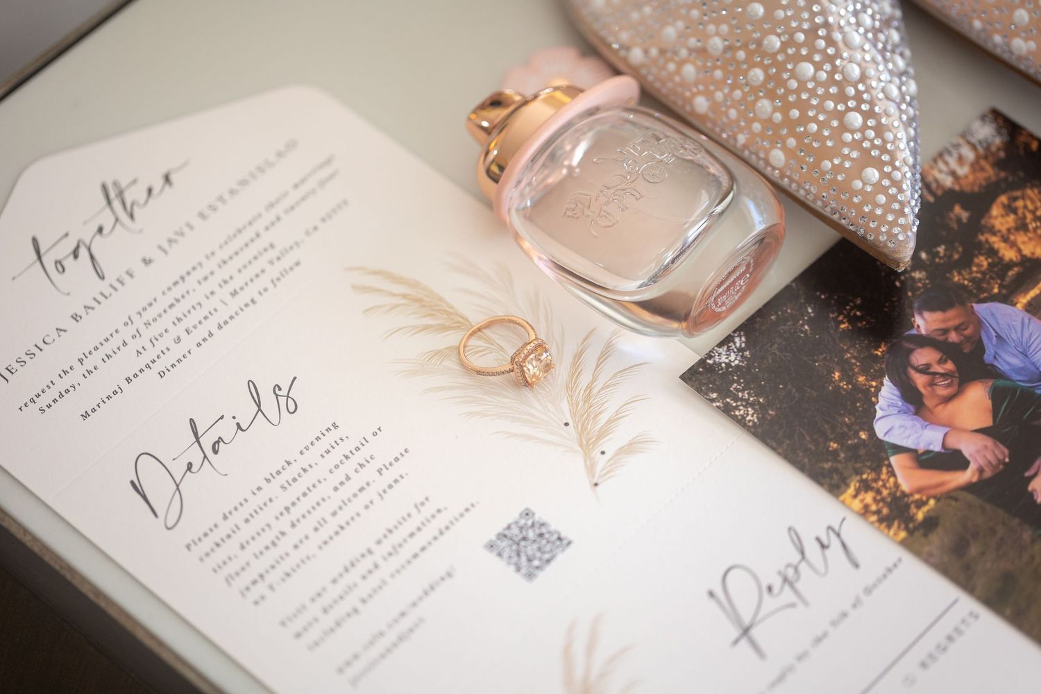 Wedding invitation suite with delicate details and rhinestone accents in soft pink tones.