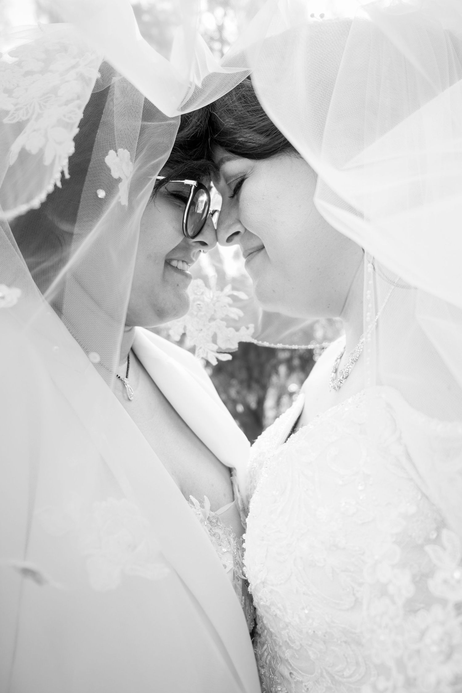 Artistic black and white wedding photography showing veils and lace details.