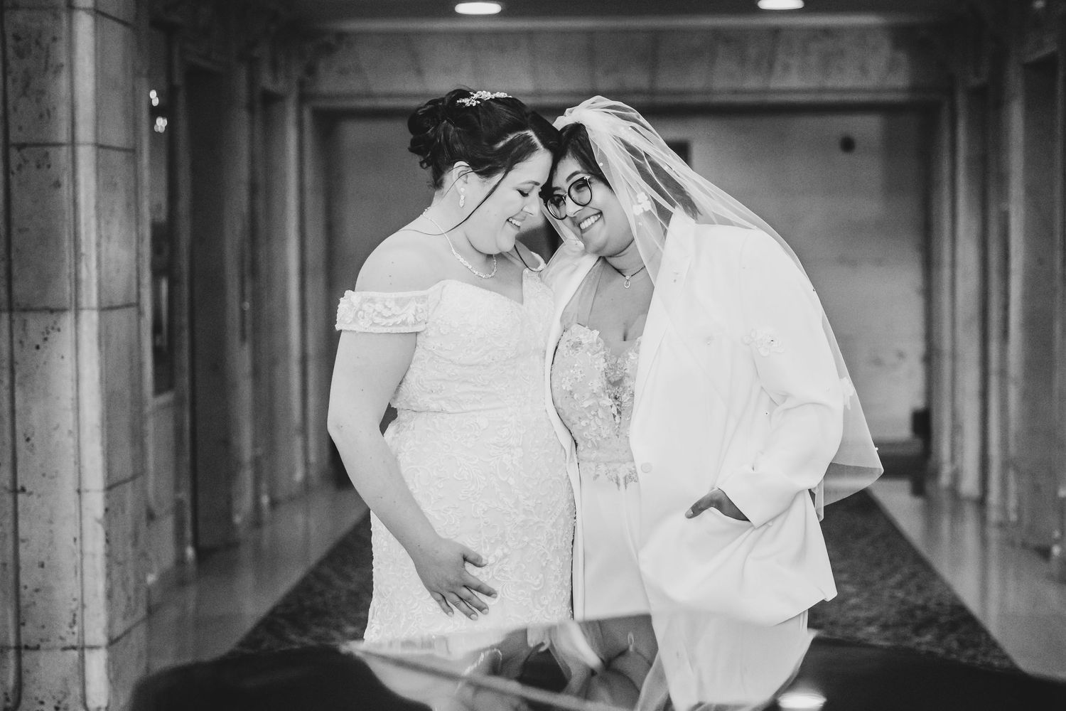 Two brides share an intimate black and white moment together in a hotel lobby in Los Angeles