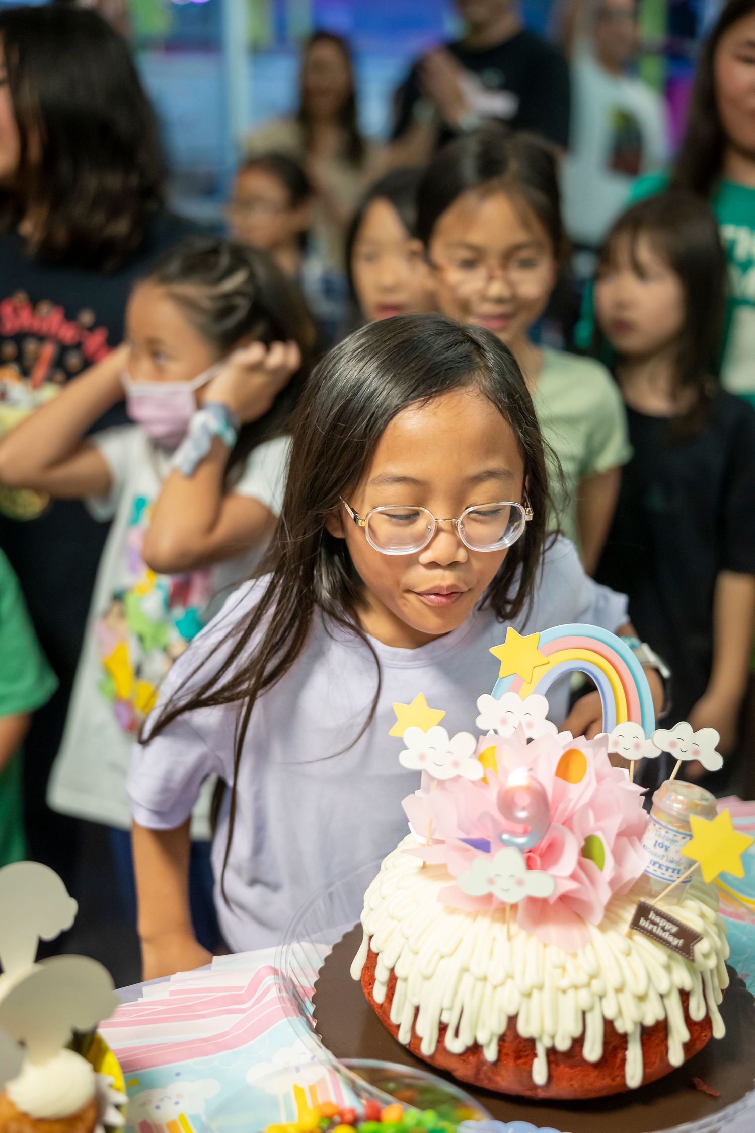 Birthday party celebration with a festive cake decorated with stars and rainbows.