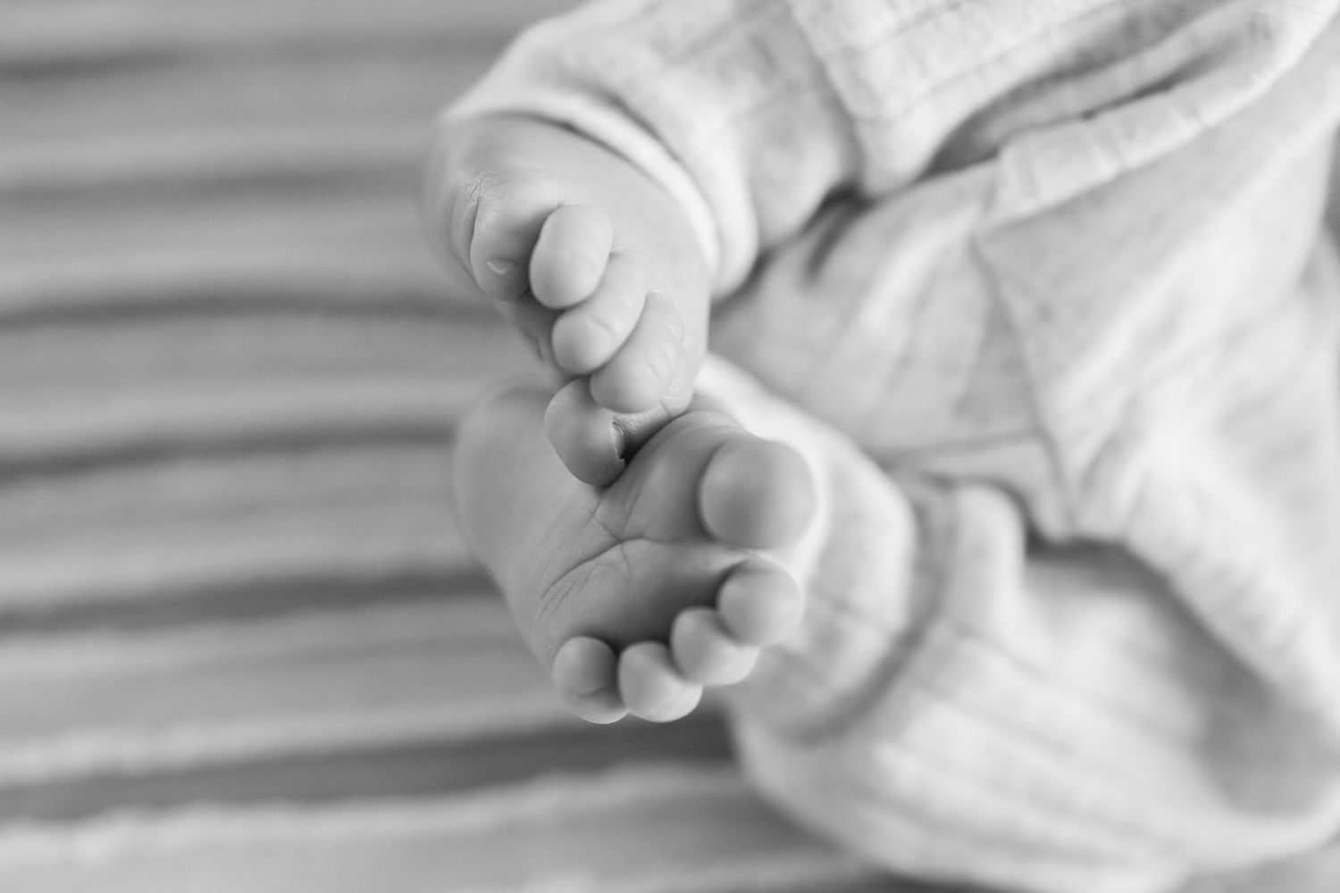 Close-up detail of soft white textured fabric and gentle hands.