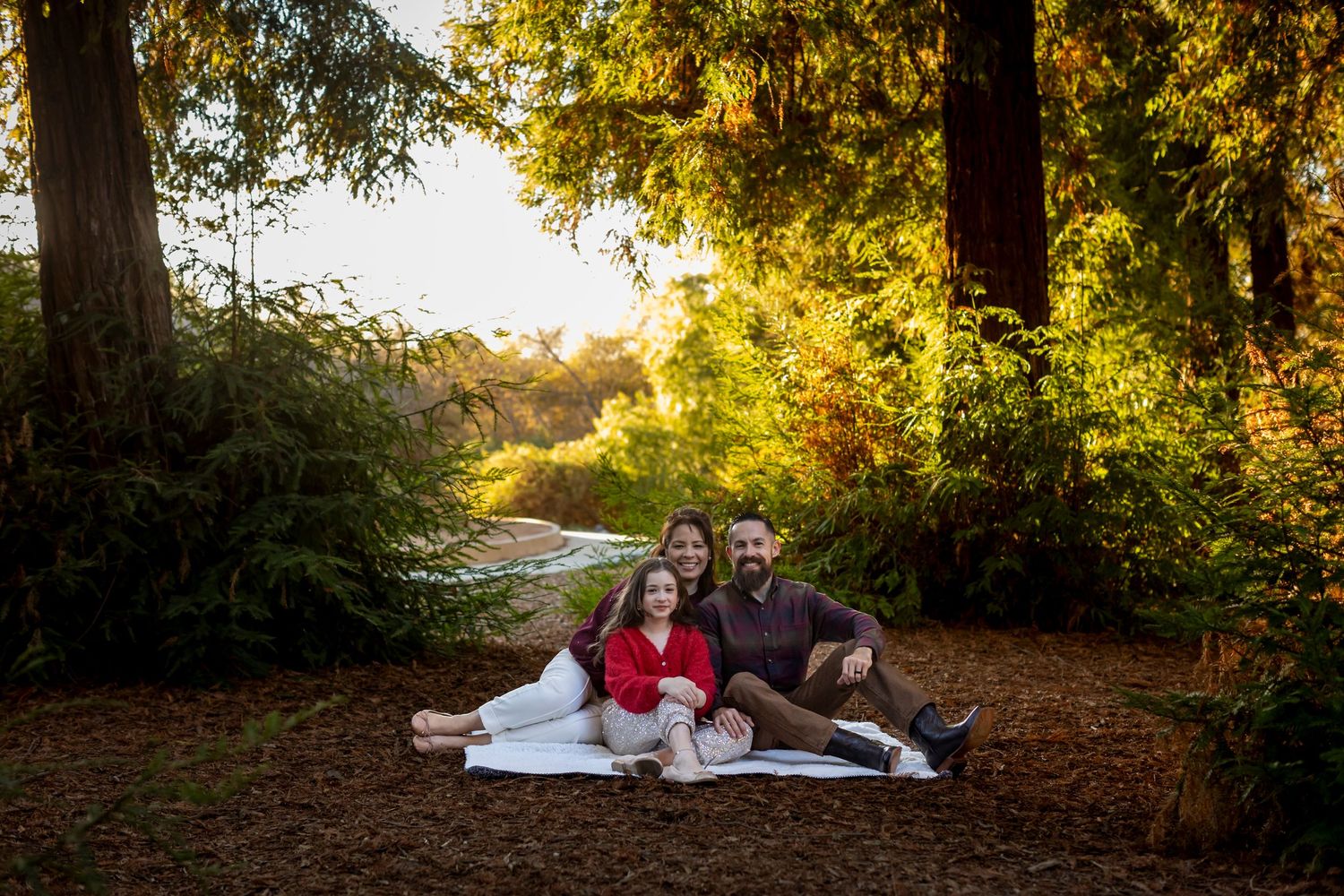 Romantic couple photos on blanket surrounded by autumn trees during golden hour.