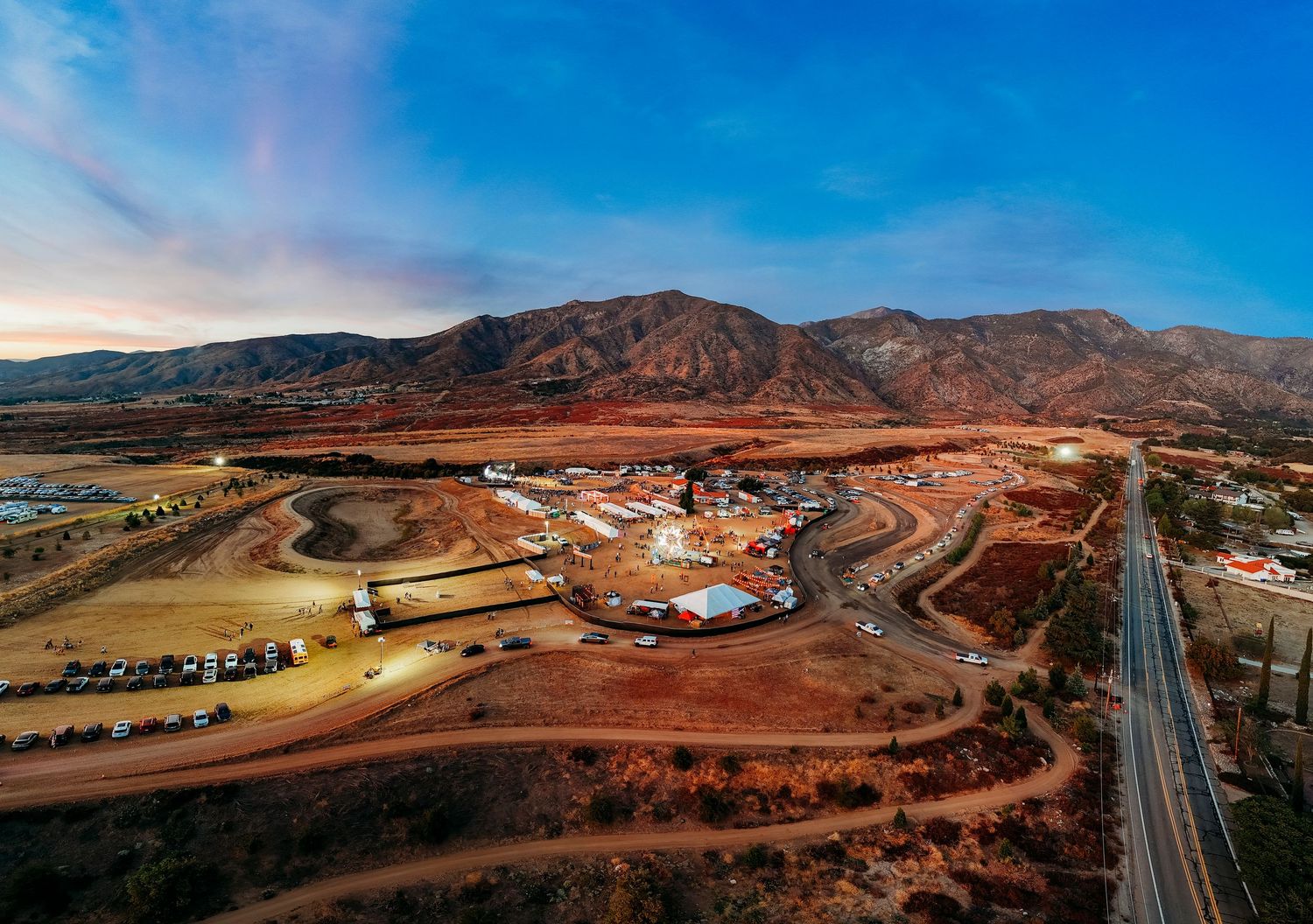 Aerial view of outdoor venue construction site in mountainous desert landscape.